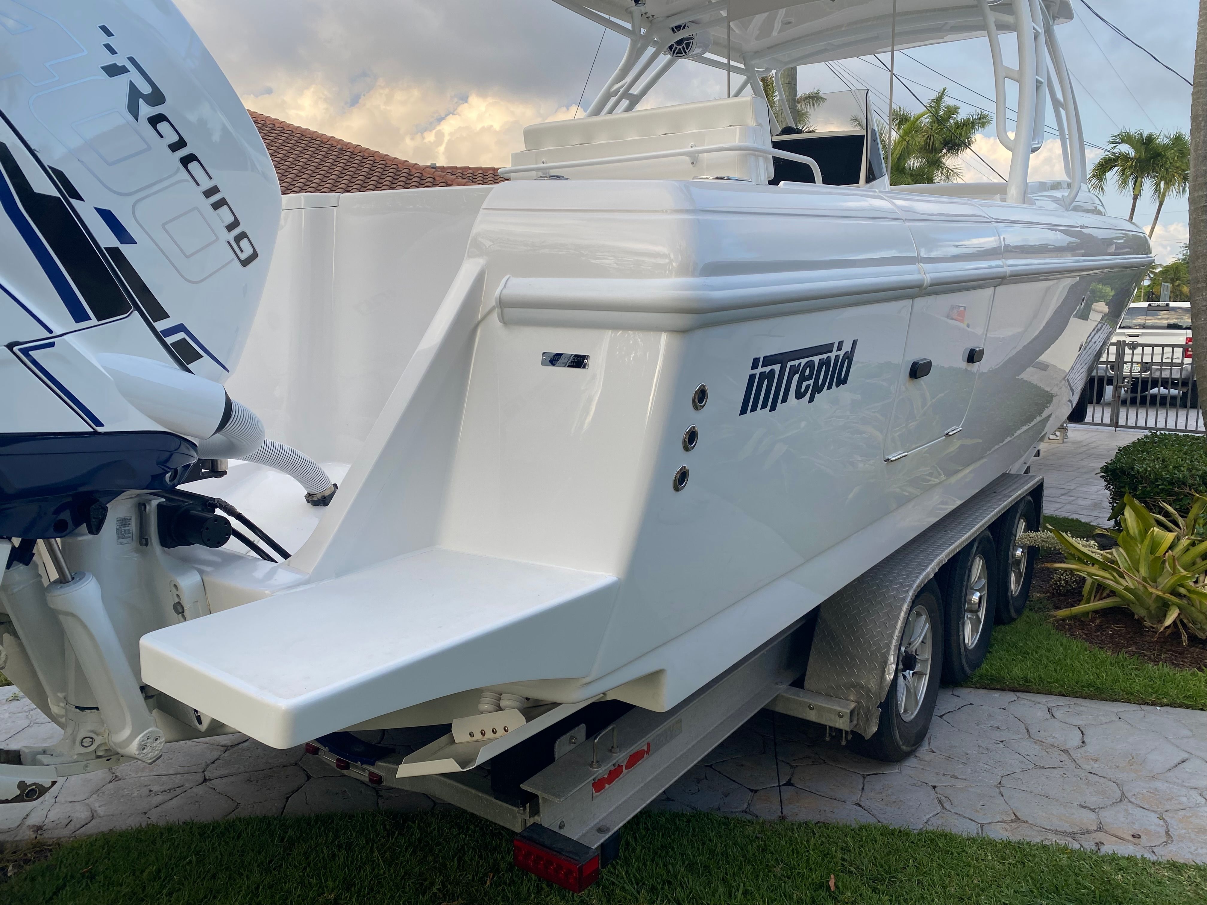 A 2011 Intrepid 37 boat on a trailer in a garden setting.