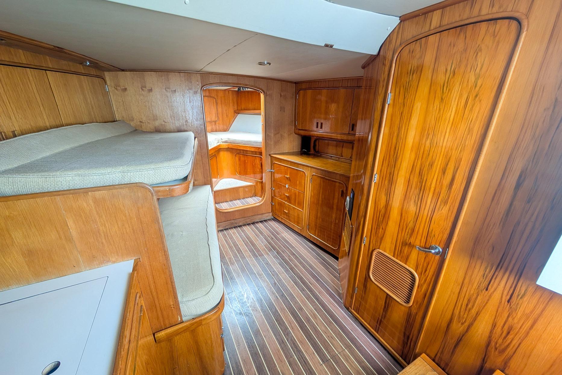 1999 Tides Custom Carolina Express interior with wooden cabinetry and cozy sleeping area.