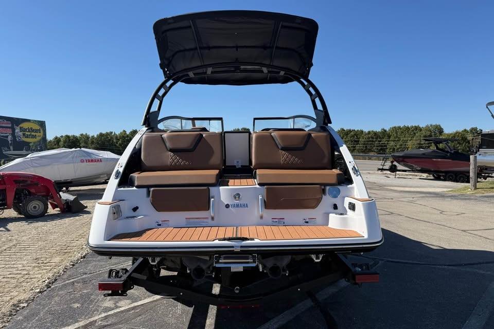 2026 Yamaha Boats 252SD with brown seating and black canopy, parked outdoors.