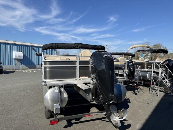 2025 Sun Tracker FB 20 DLX pontoon boat with outboard motor in a parking lot.