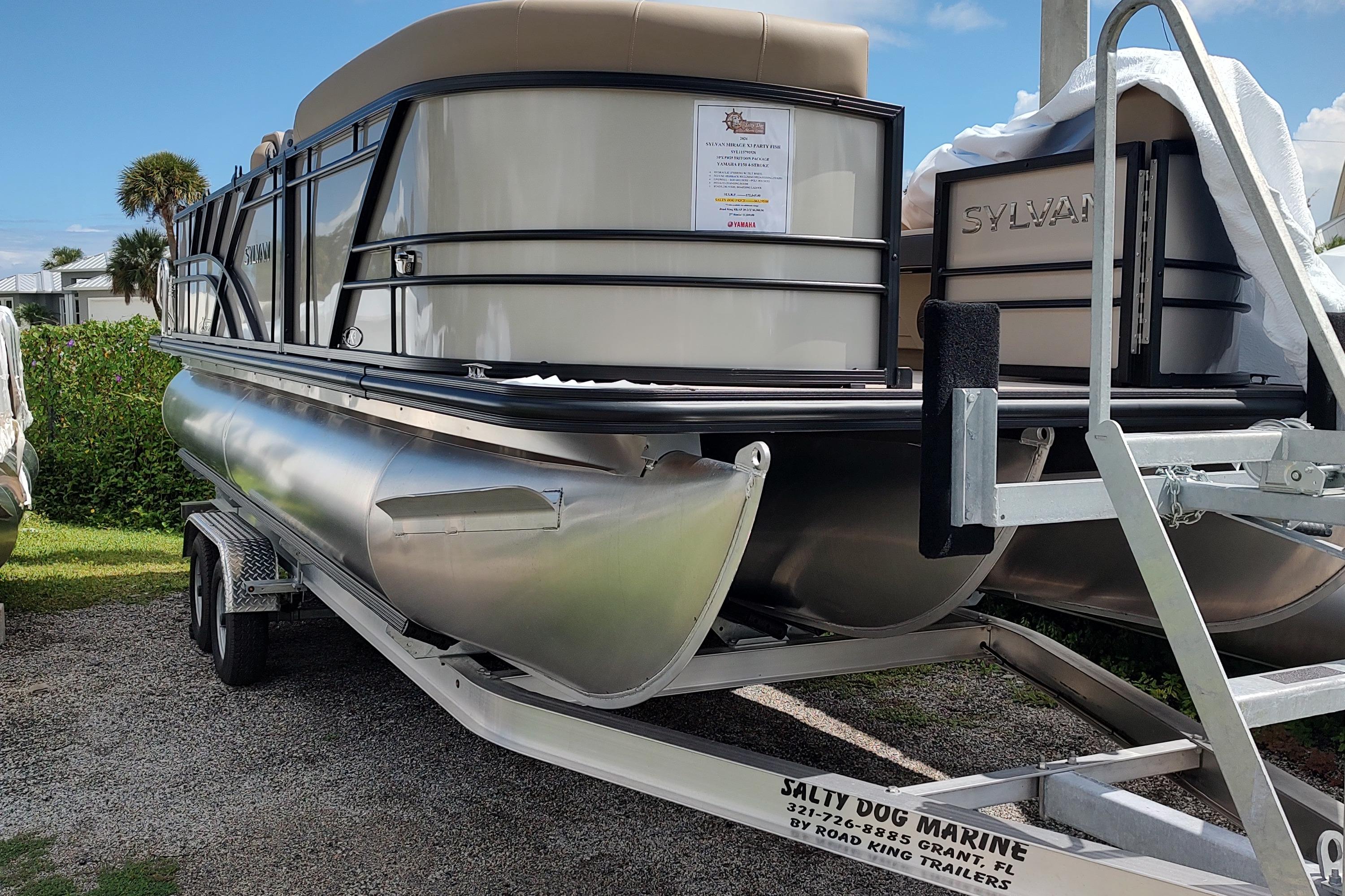 2026 Sylvan Mirage X3 Party Fish pontoon boat on trailer, displayed outdoors.