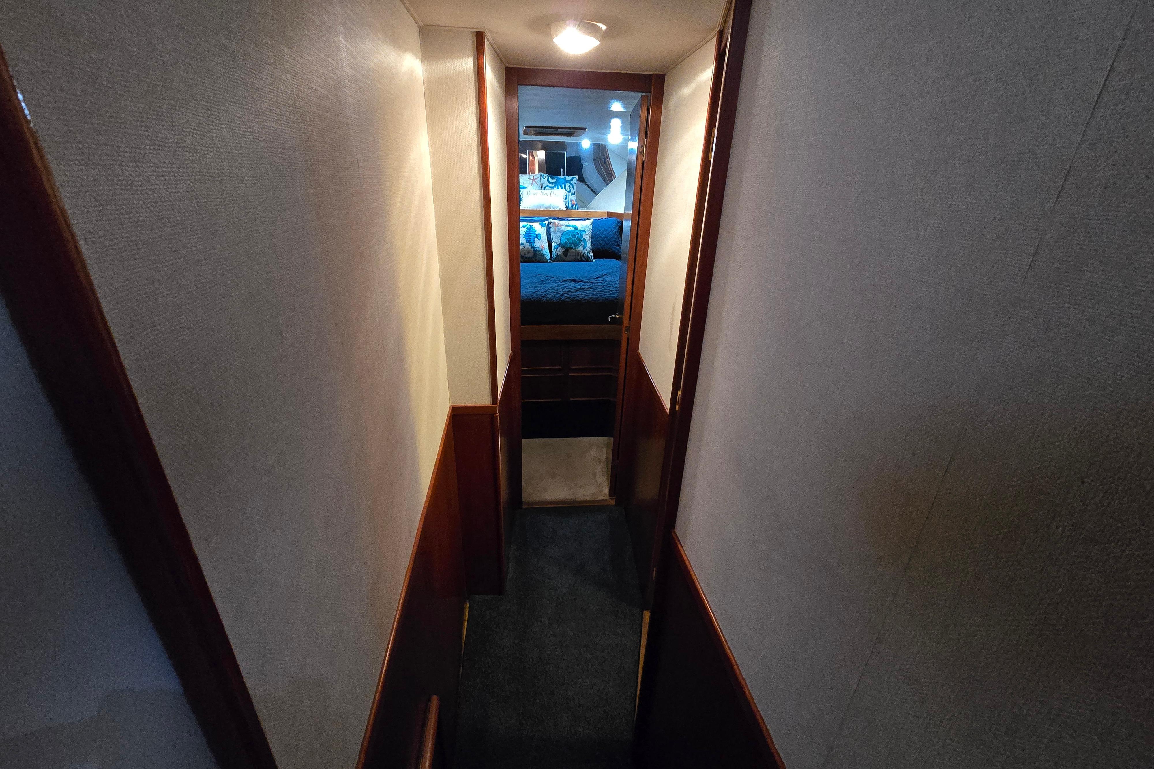 Narrow hallway leading to a cozy bedroom in a 1988 Post 46 Convertible yacht.