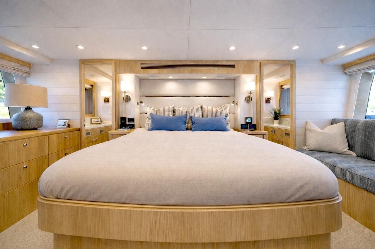 Luxurious bedroom interior of 2027 Offshore Yachts 70 CE, featuring elegant wood finishes and modern decor.