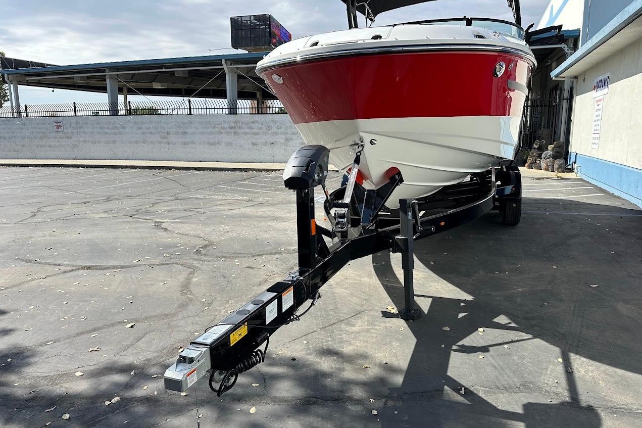 2026 Sea Ray SDX 230 Surf boat on trailer, red and white exterior, parked outdoors.