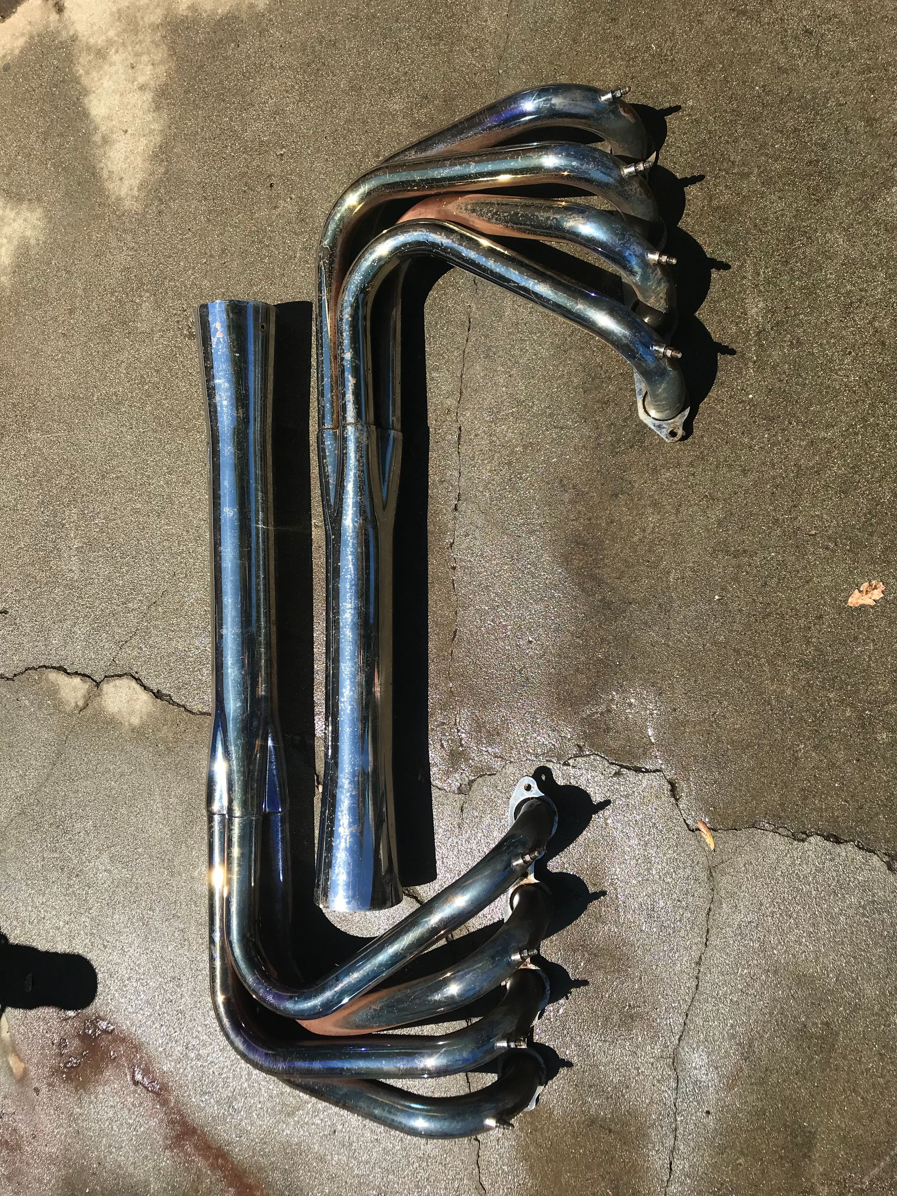 Exhaust headers of a 1976 Tahiti Day Cruiser on concrete surface.