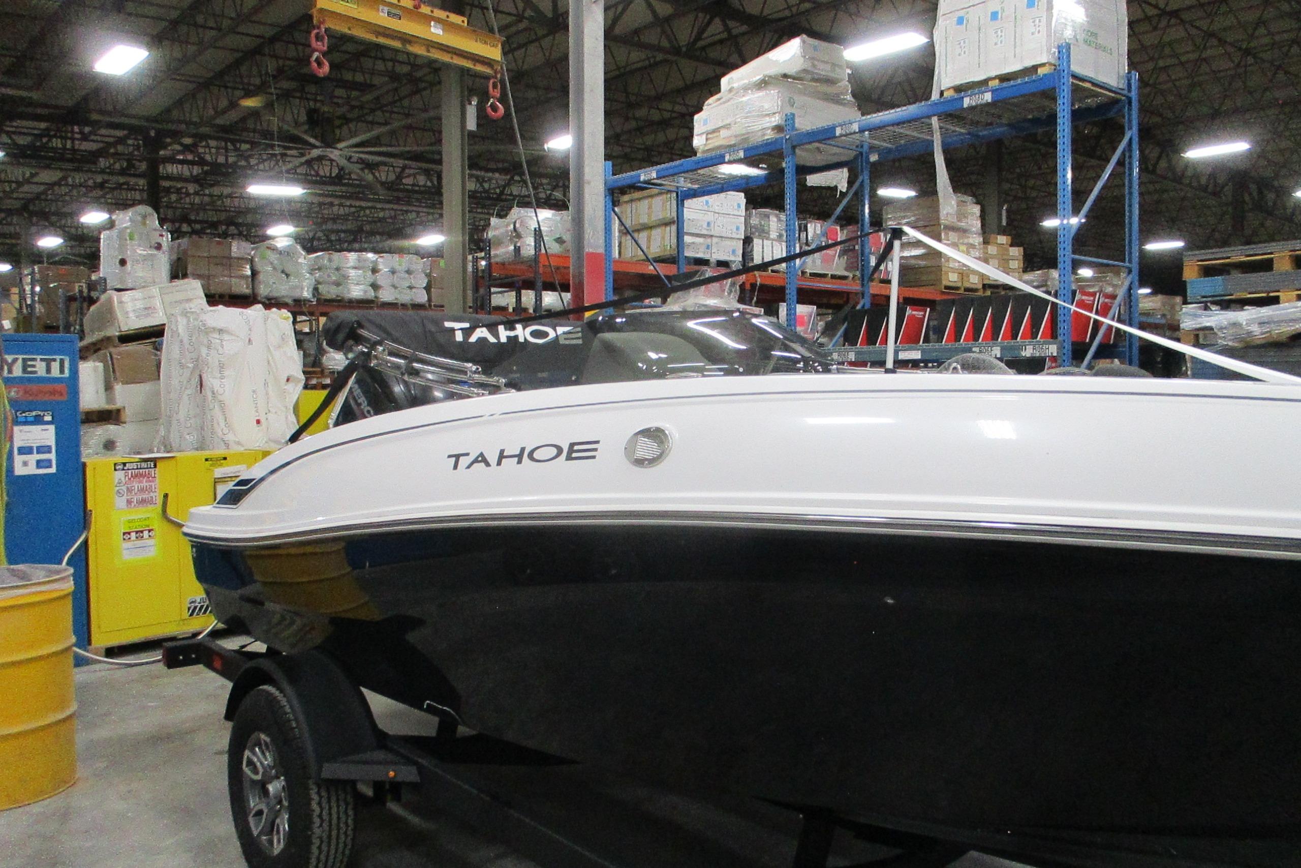 2025 Tahoe T18 boat in warehouse, on trailer, surrounded by industrial shelving.