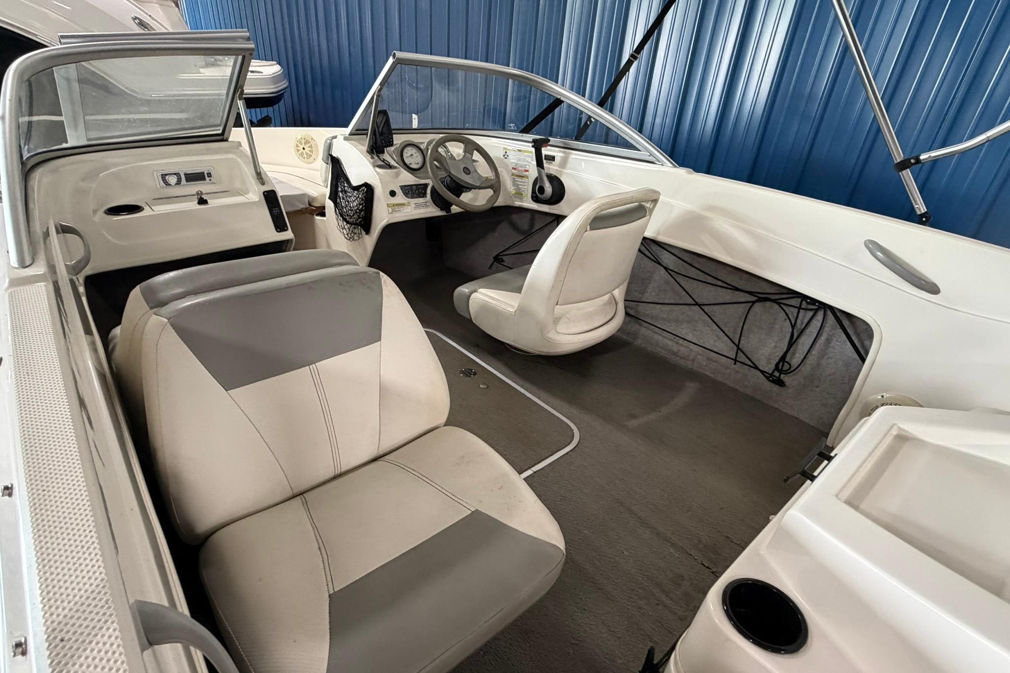 2012 Bayliner 175 Bowrider interior with steering wheel, seats, and dashboard in a blue setting.
