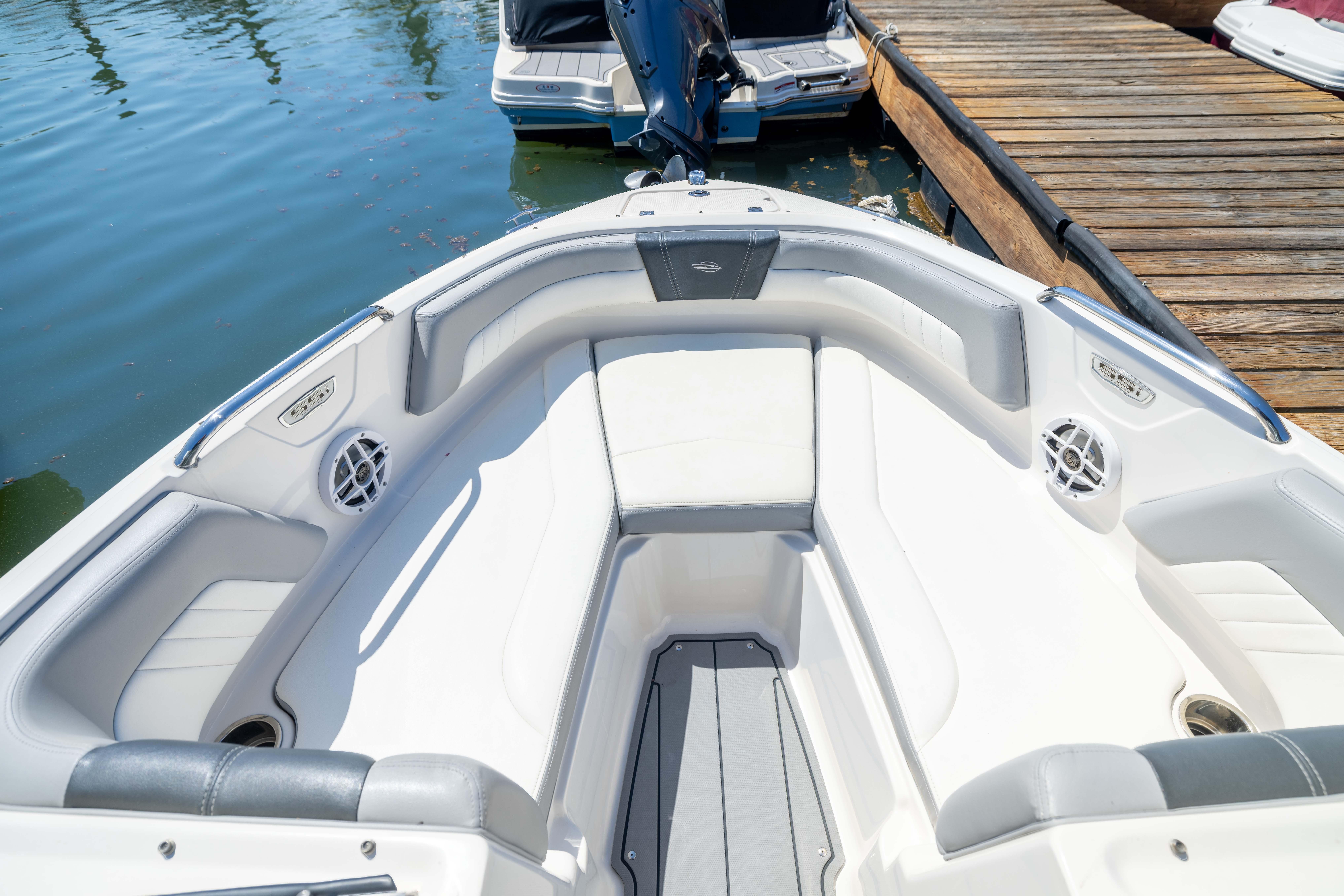 2022 Chaparral 21 SSi OB boat interior with white seating and sleek design at dock.