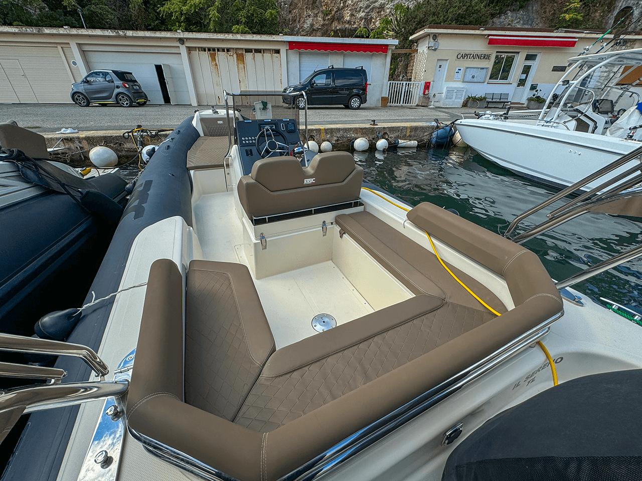 BSC 78 boat, 2019 model, docked with brown seating and control panel, near waterfront buildings.