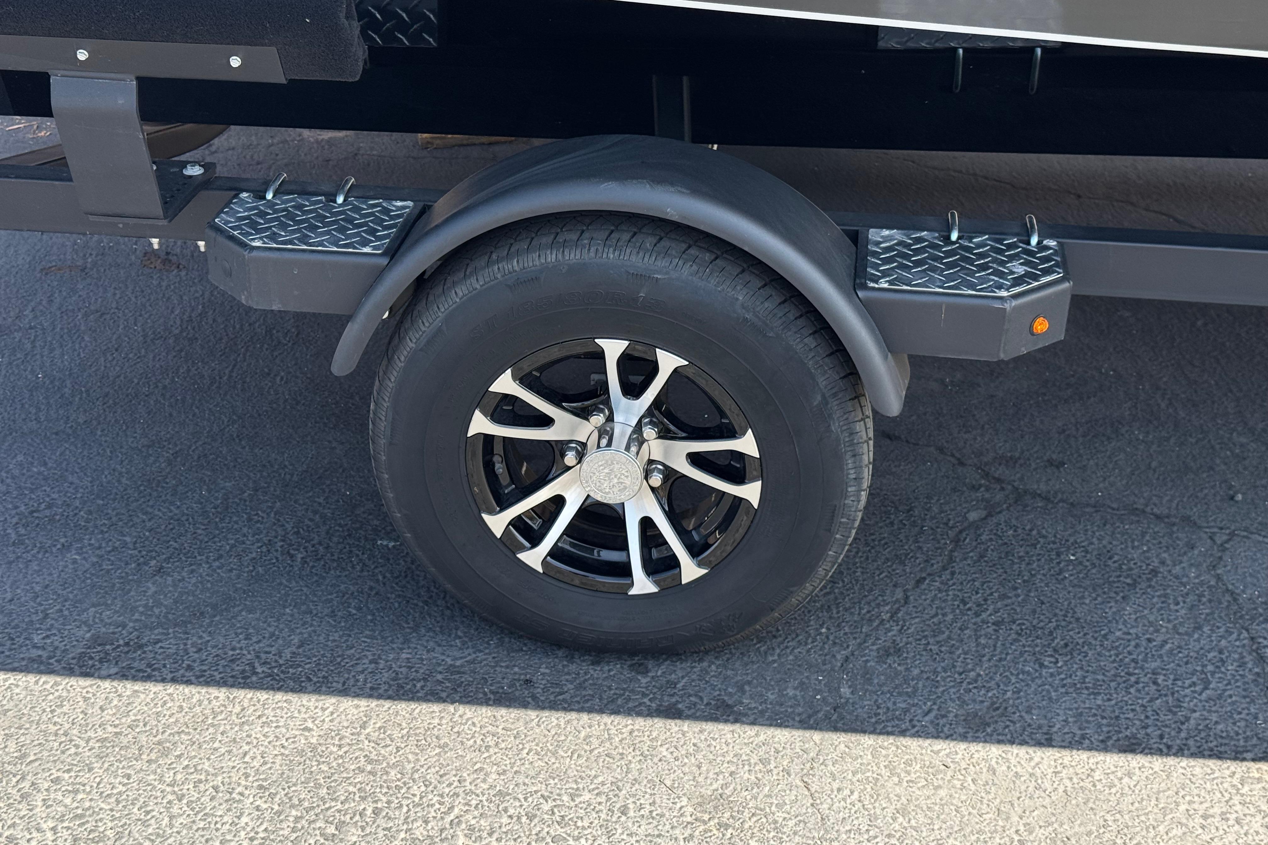 2024 Lowe Stinger 175 trailer wheel with black alloy rim and diamond plate step.