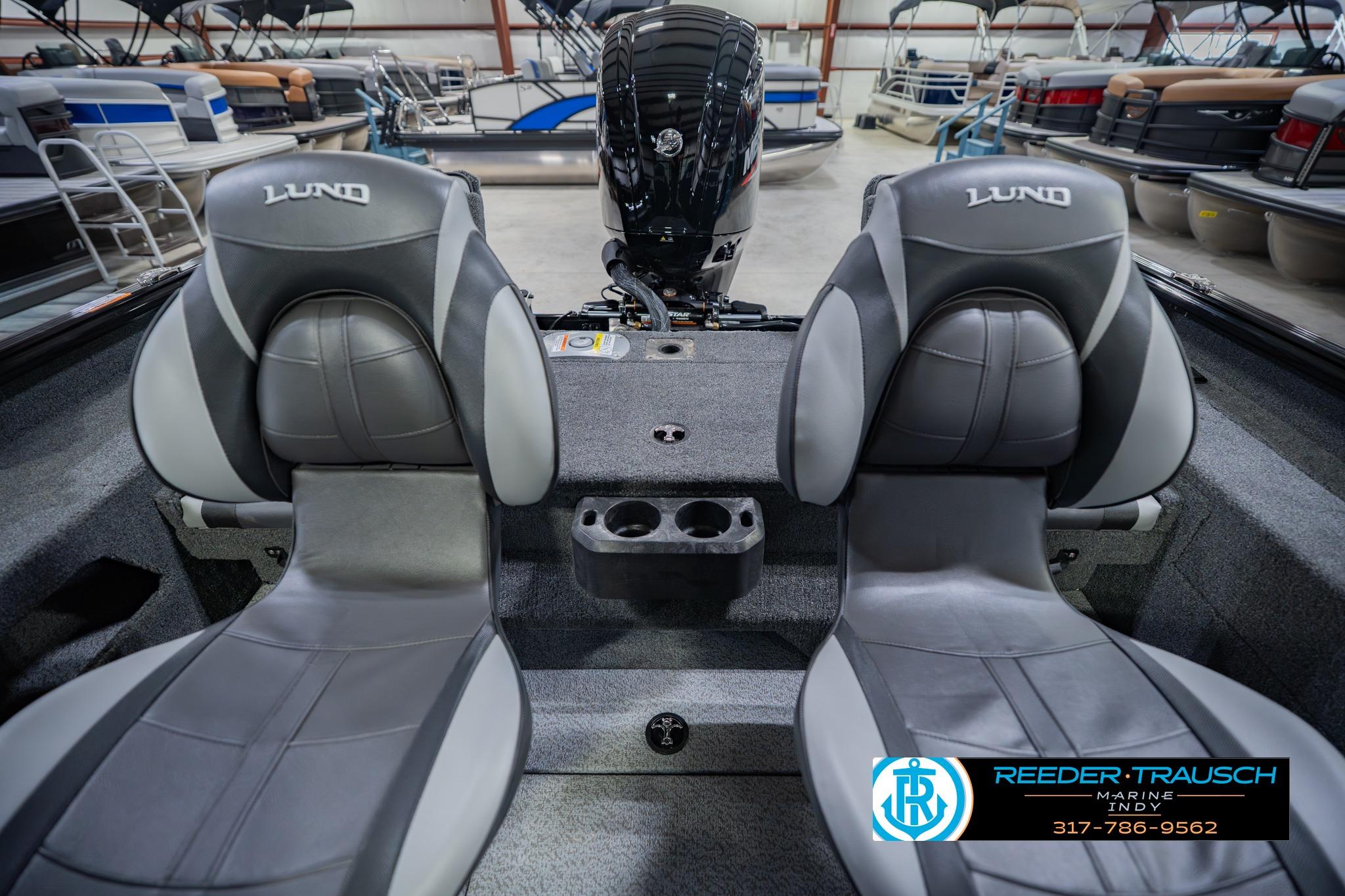 2026 Lund 1775 Impact XS boat interior with dual seats and motor in showroom.
