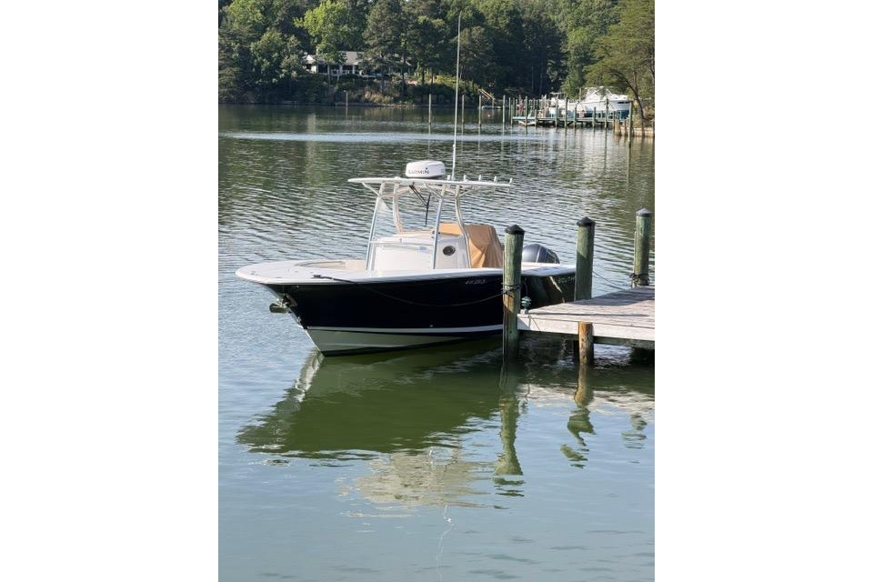 2014 Southport 29 FE boat docked on a calm lake with lush greenery.