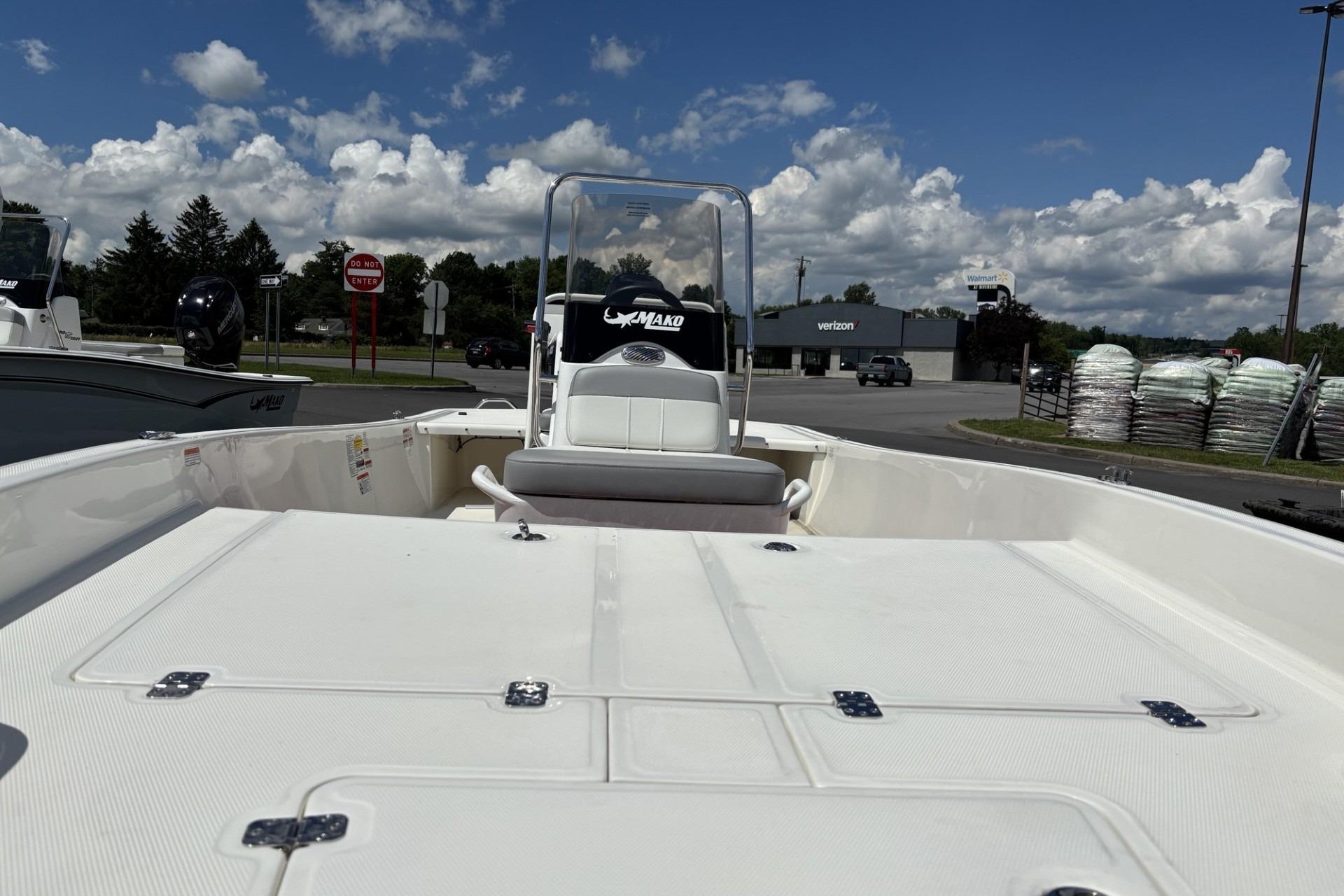 2026 Mako Pro Skiff 15 CC boat with open deck, parked outdoors under a cloudy sky.