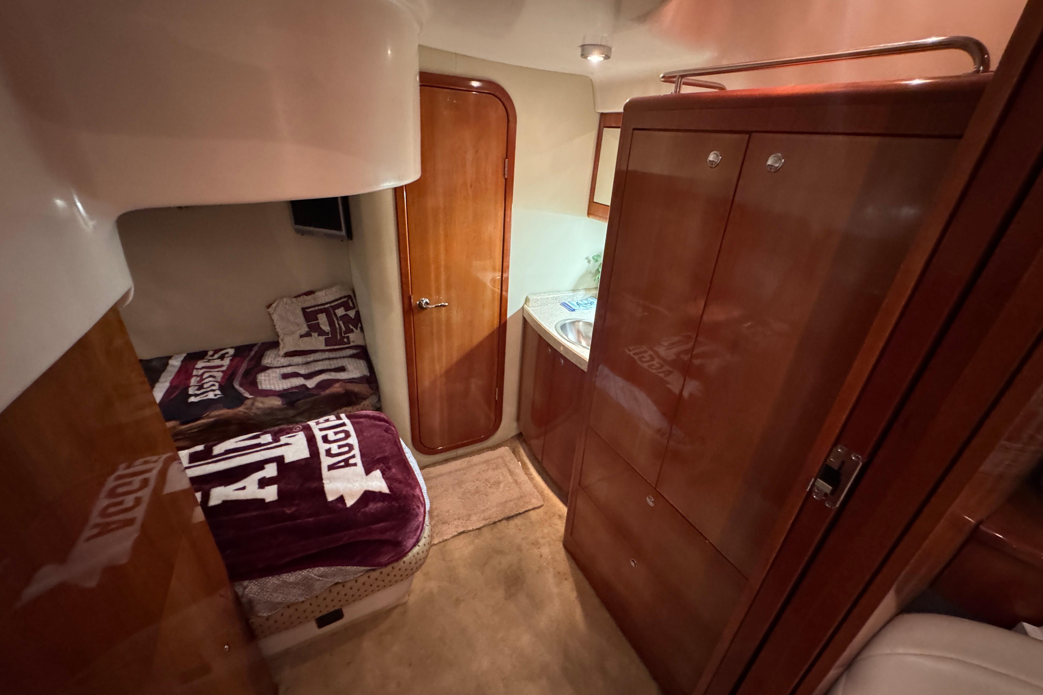 Interior of 2005 Regal Commodore 4260 yacht with cozy cabin and wooden cabinetry.