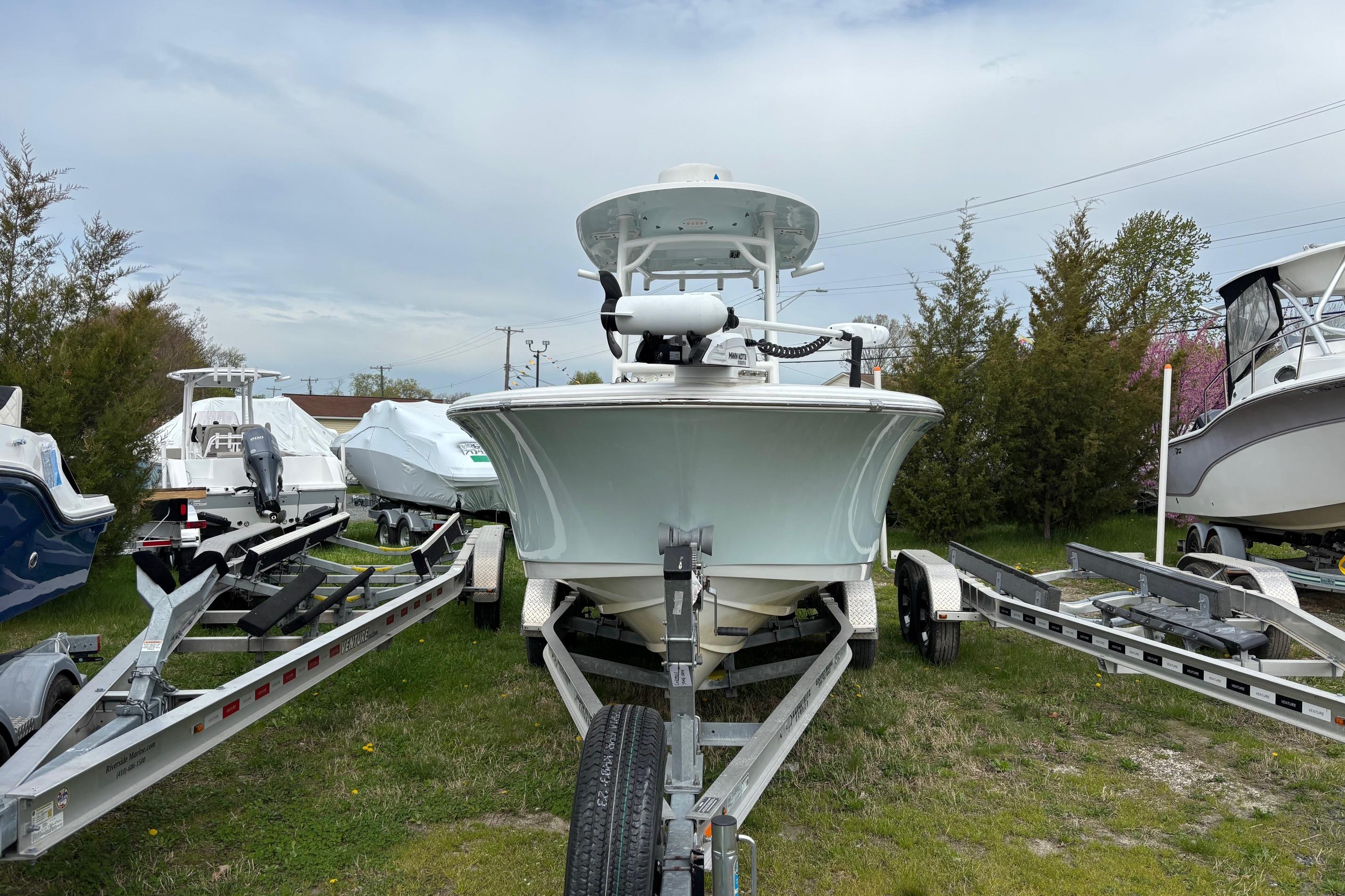 2018 Sportsman Heritage 231 Center Console boat on trailer, surrounded by trees and other boats.
