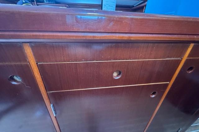 Wooden cabinetry inside a 1996 Beneteau 50 sailboat, featuring drawers and storage compartments.