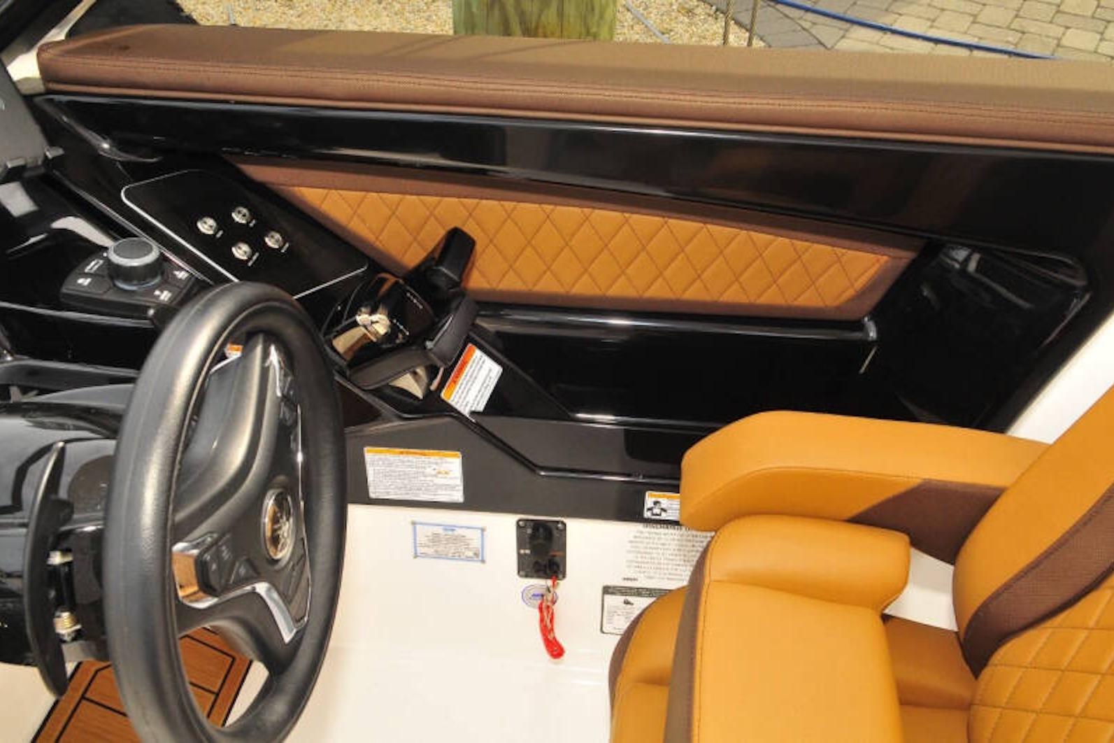 2024 Yamaha Boats 275SDX cockpit with luxurious tan and black interior design.