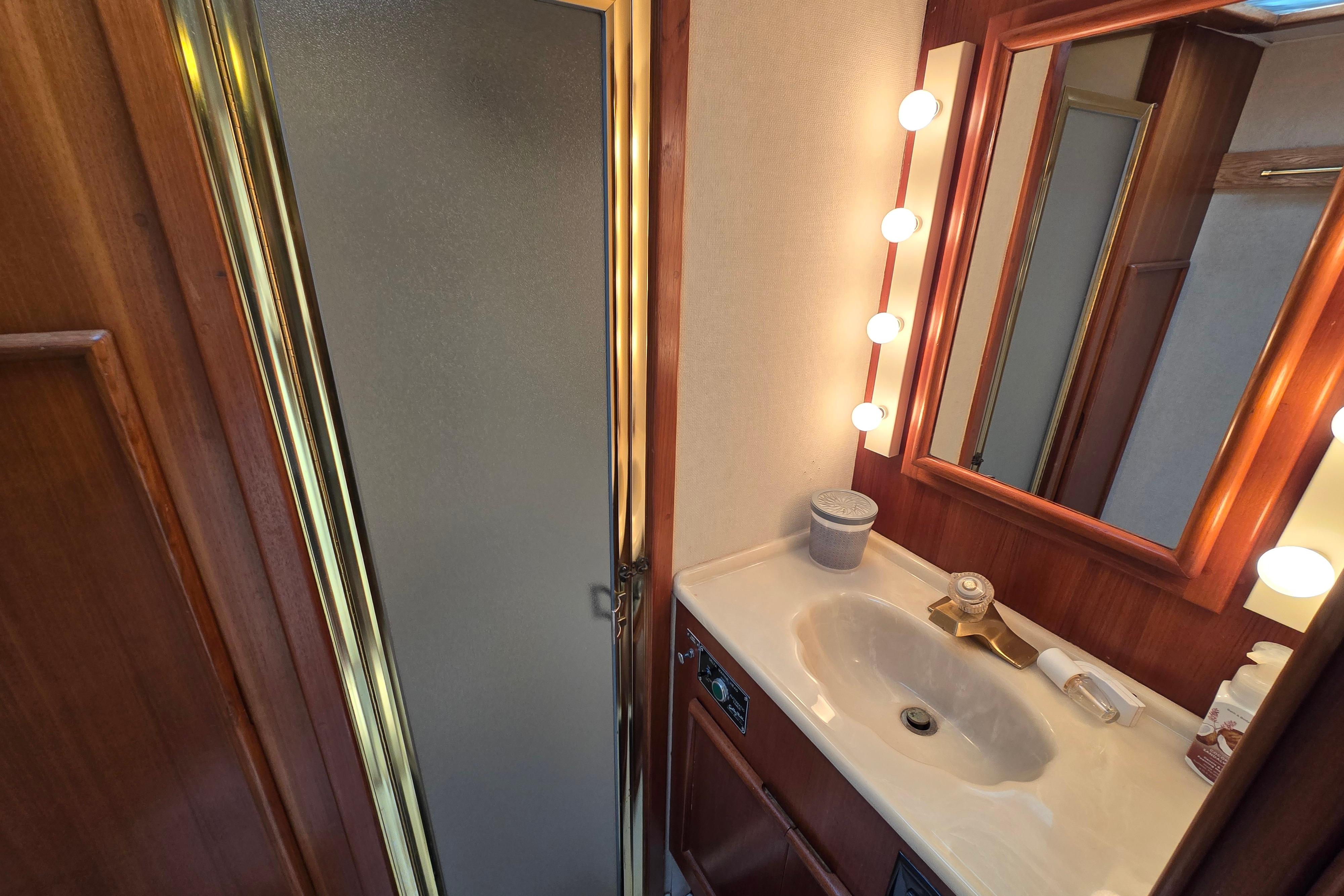 Luxurious 1988 Post 46 Convertible yacht bathroom with vanity, mirror, and shower.