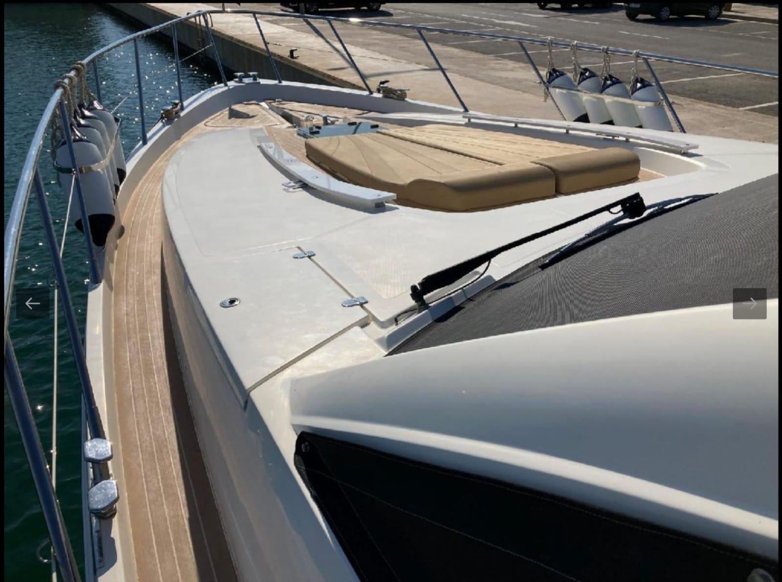 2005 Sealine T60 yacht deck with sunbed and railing, docked at marina.
