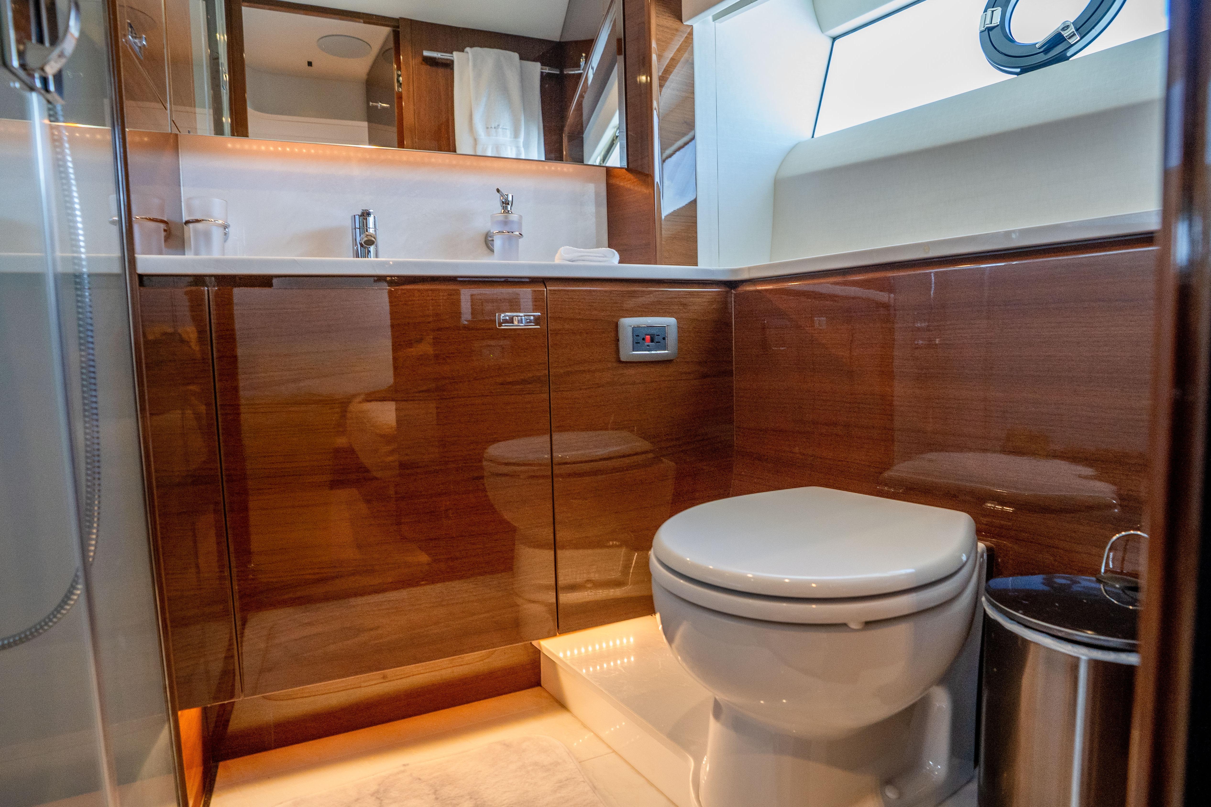 Luxurious bathroom in 2020 Princess Y85 yacht with modern fixtures and wooden cabinetry.
