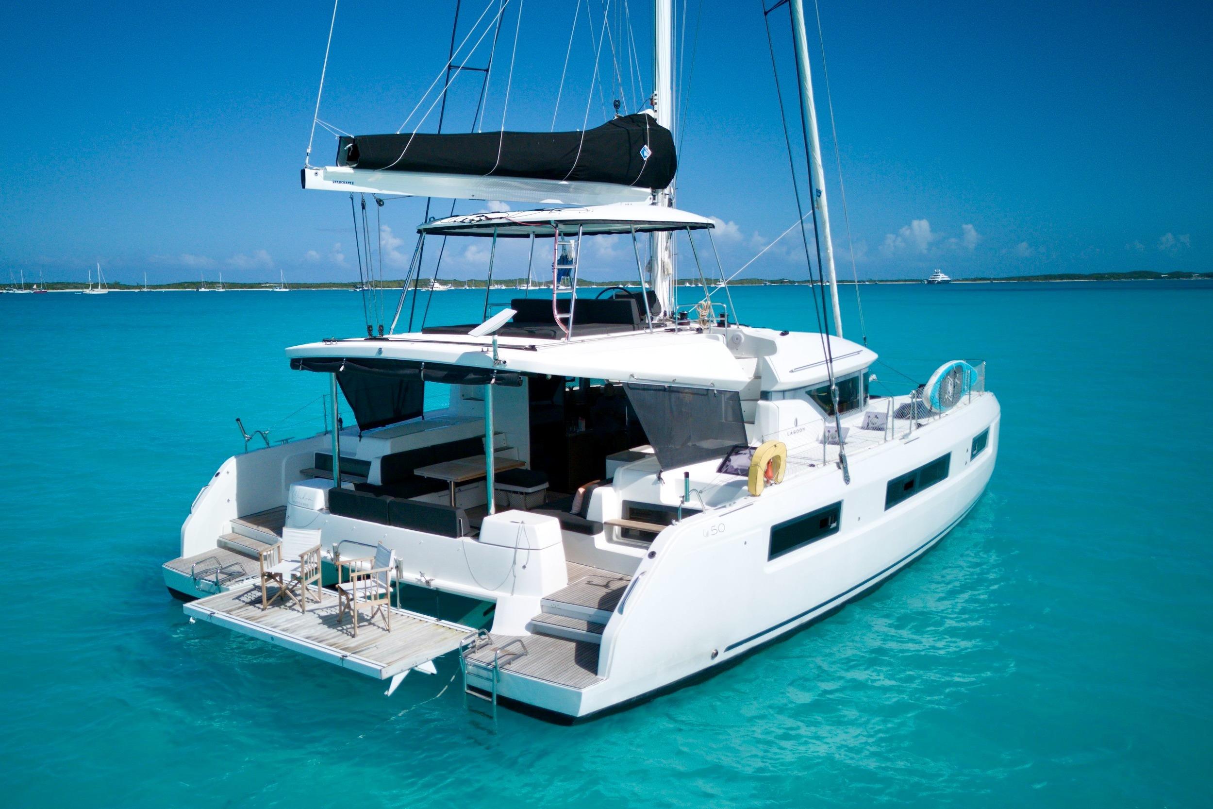 2023 Lagoon 50 catamaran sailing on clear turquoise waters under a bright blue sky.
