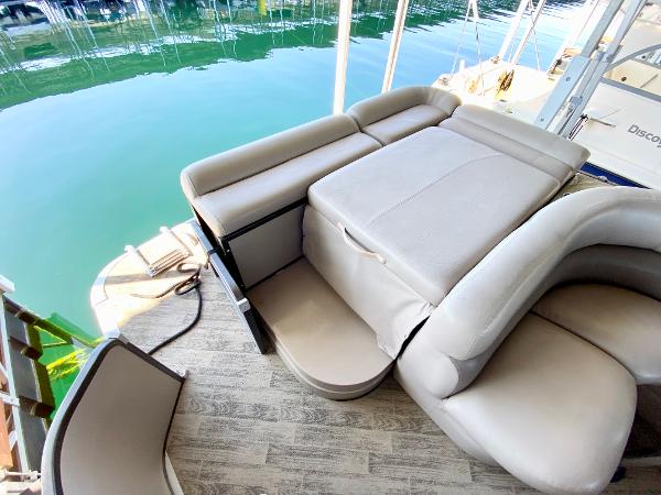 Luxurious seating area on a boat with calm water in the background.