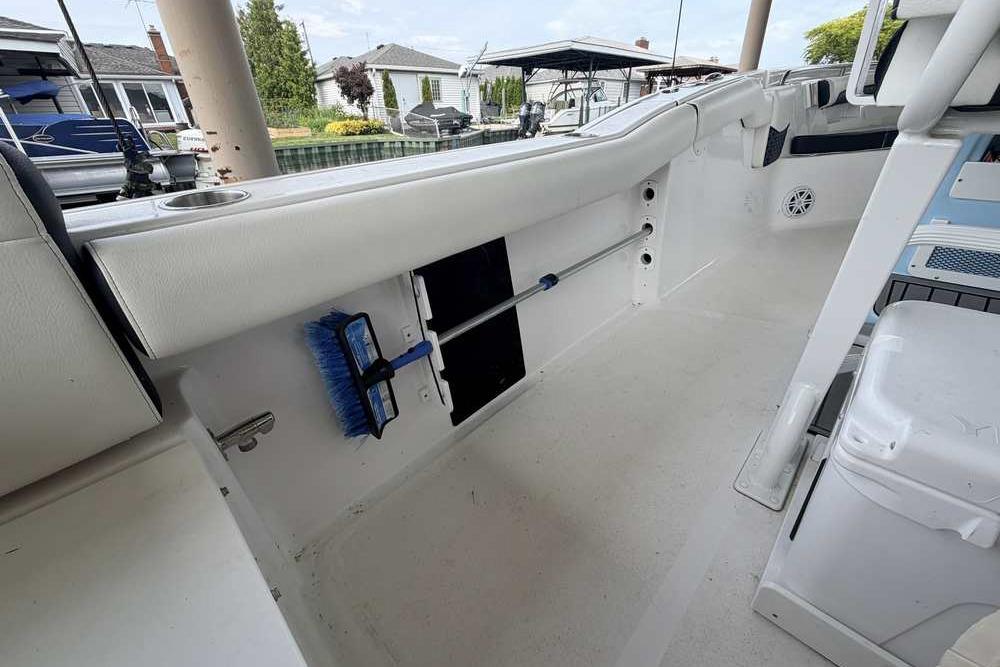 2024 Tidewater 232 LXF boat interior with storage and cleaning tools.