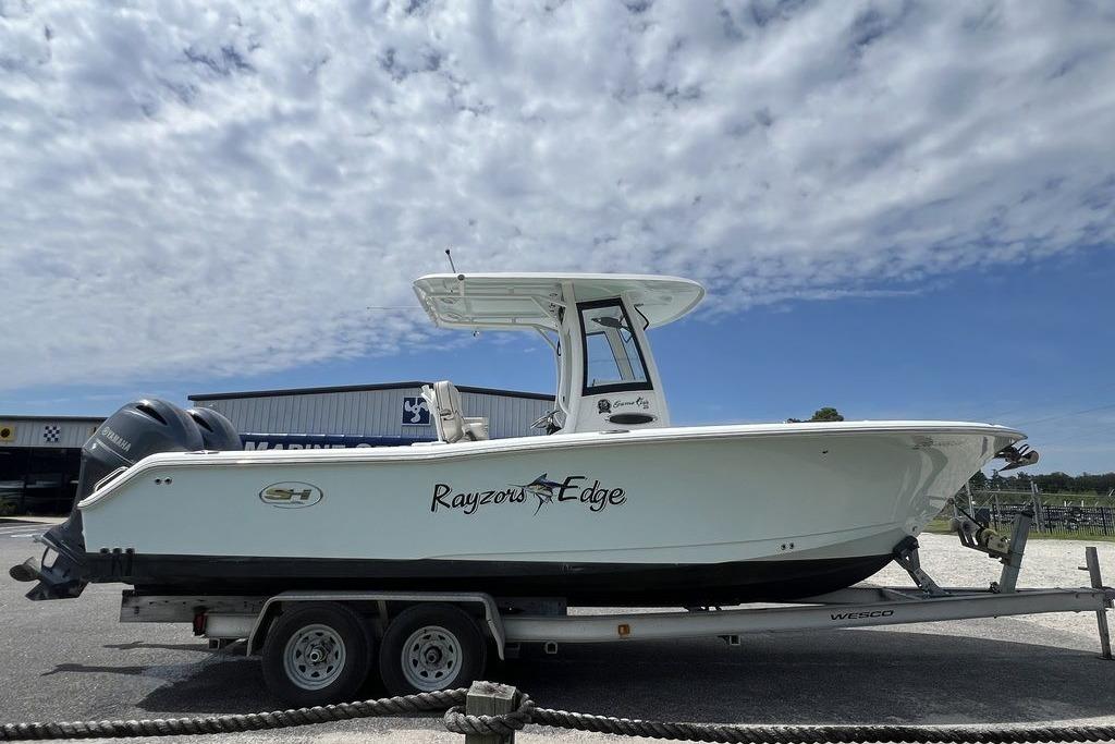 2021 Sea Hunt Gamefish 25 boat on trailer under cloudy sky.