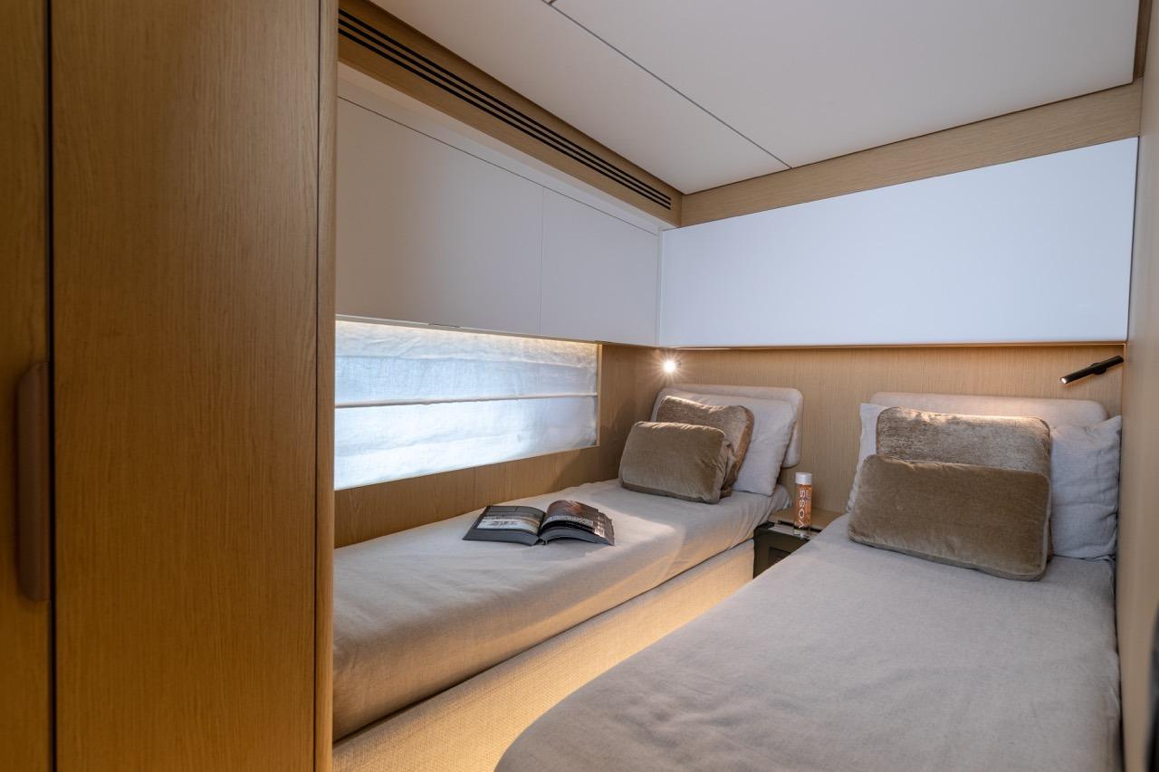 Luxurious twin cabin interior on 2025 Azimut Fly 62 yacht, featuring modern design and cozy bedding.