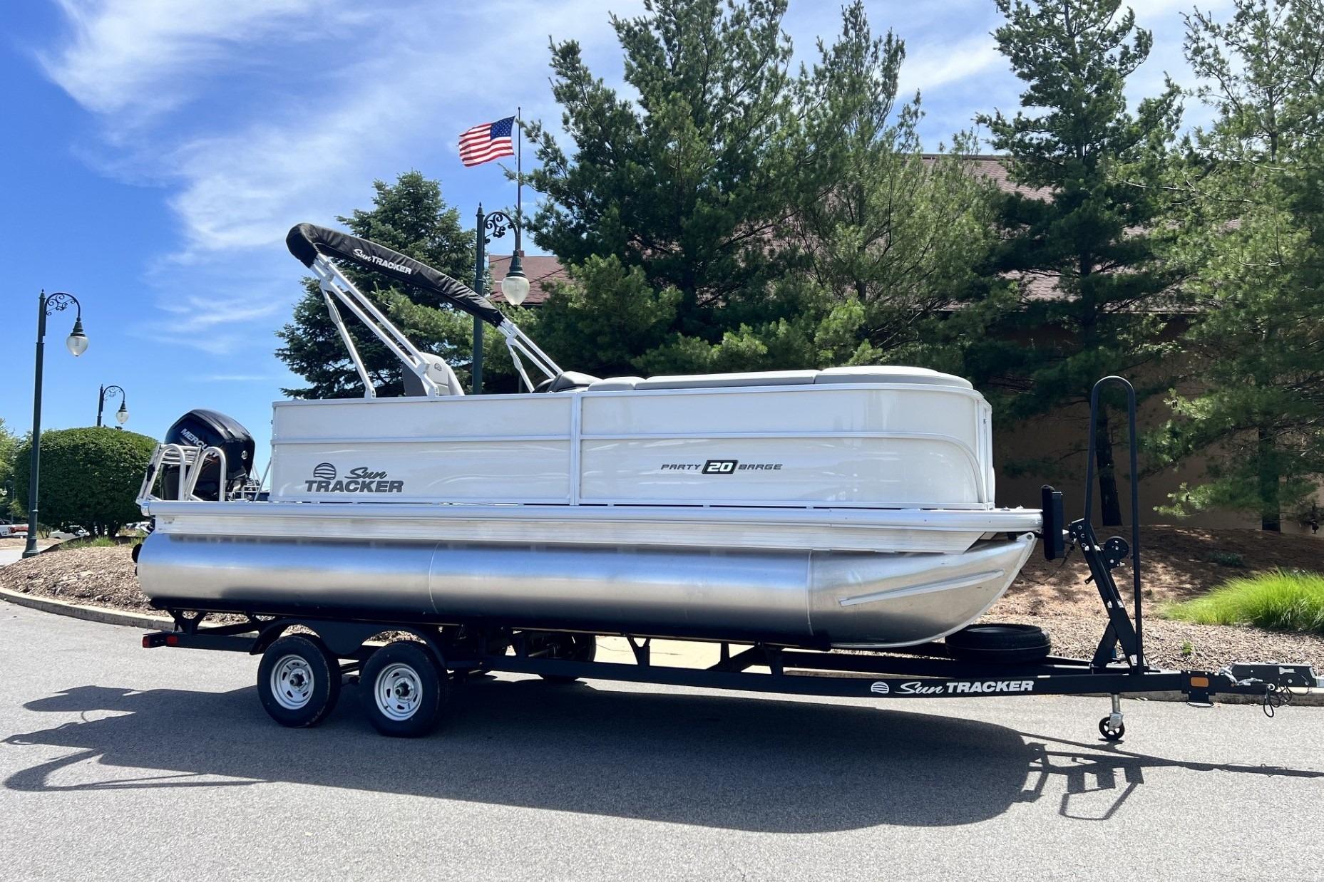 2026 Sun Tracker Party Barge 20 DLX pontoon boat on trailer, parked outdoors.