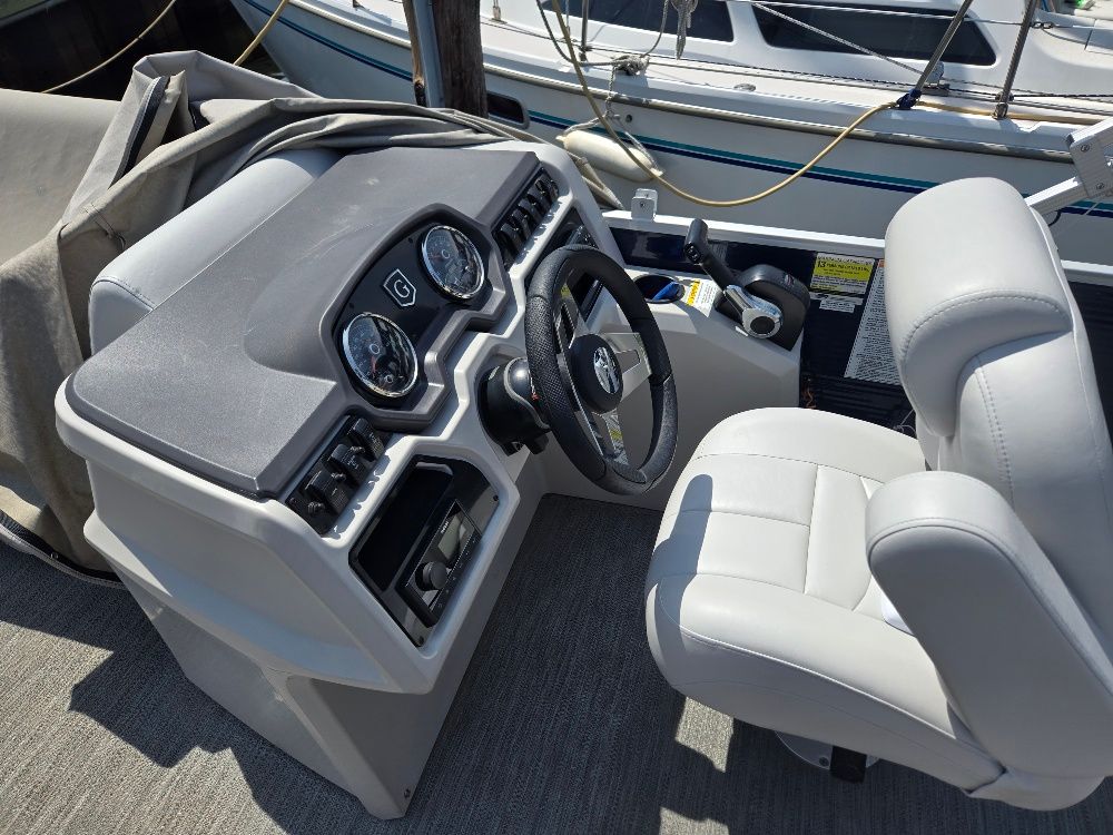 The image shows the helm of a 2022 Godfrey Sweetwater 2186C with gray seating.