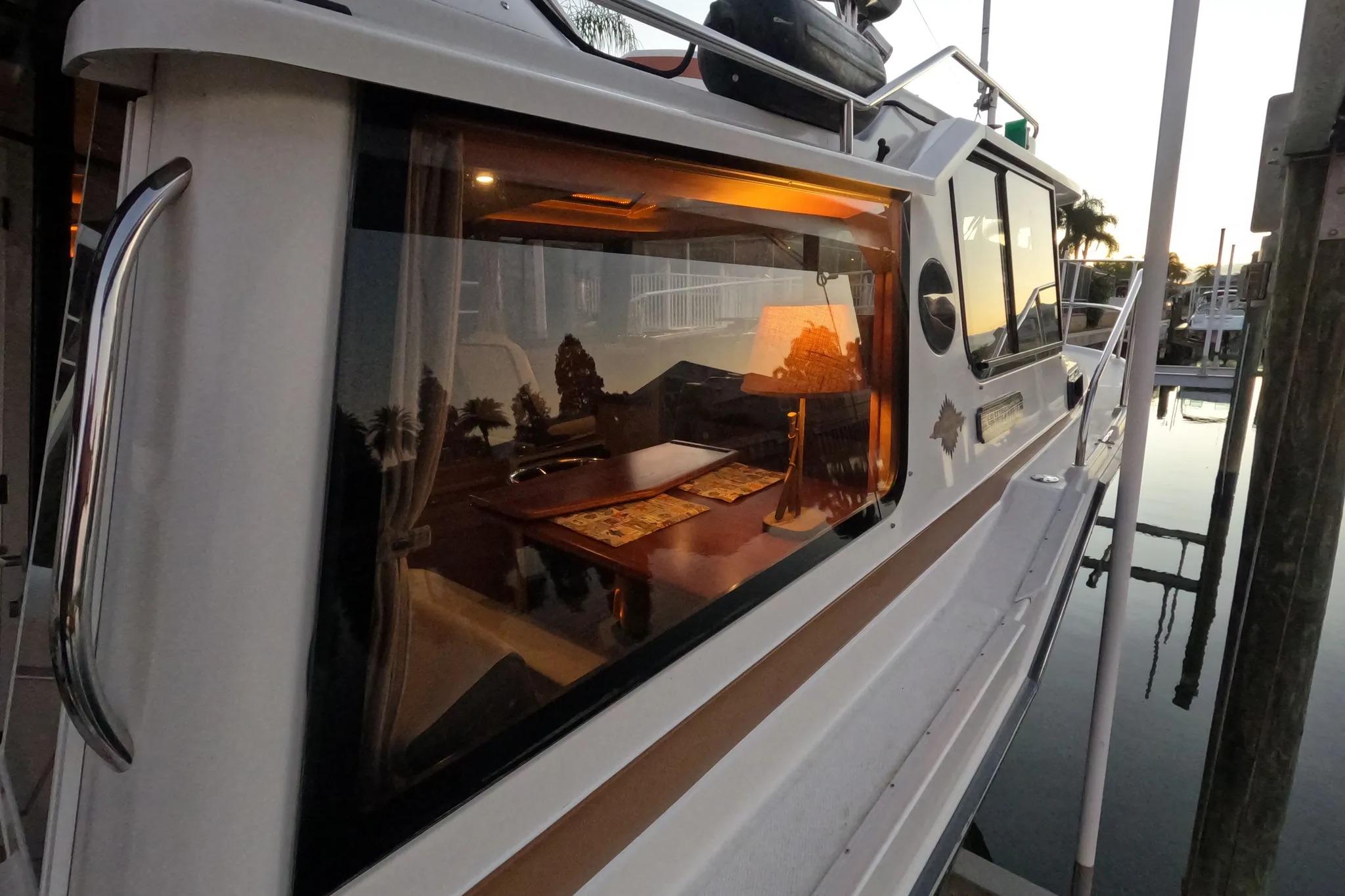 2015 Ranger Tugs R-29 S boat with illuminated interior, docked at sunset.