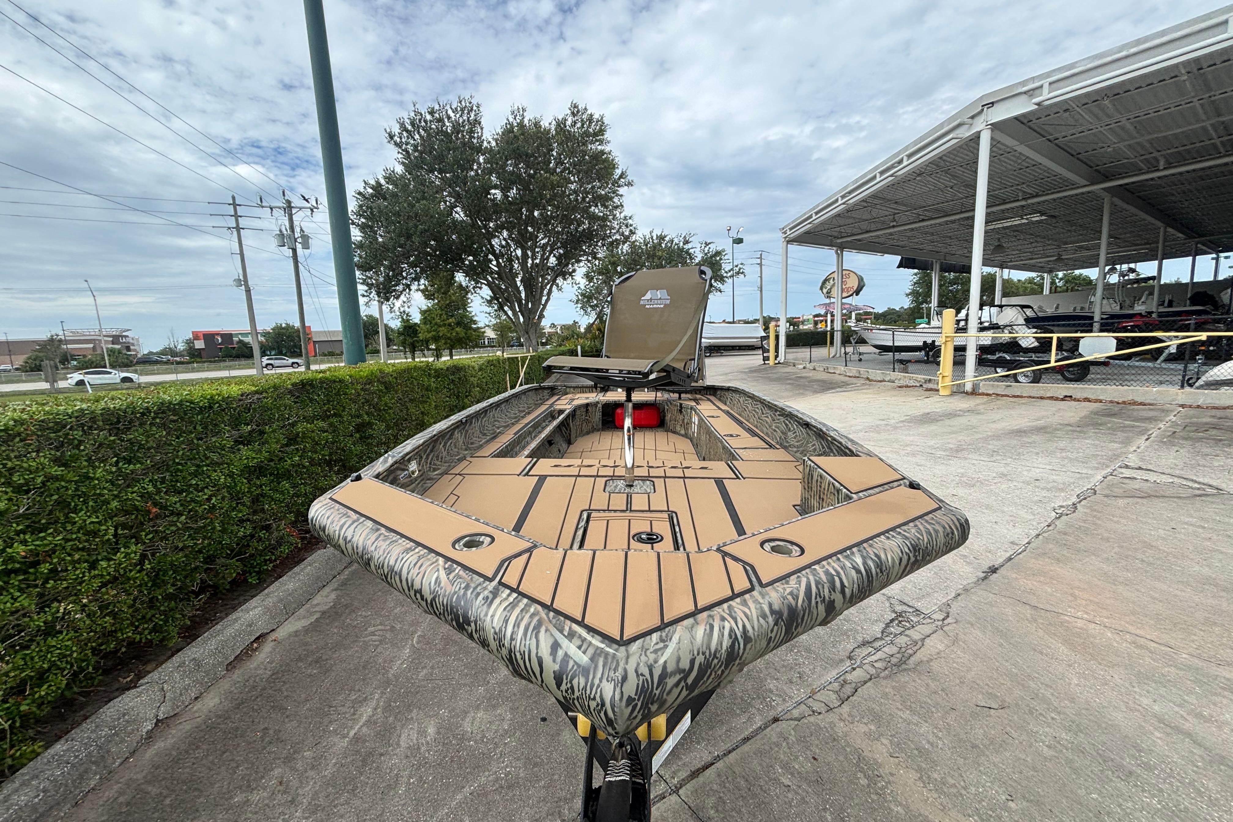 2026 Tracker Grizzly 1756 T Marsh boat displayed outdoors, showcasing its camo design and spacious deck.