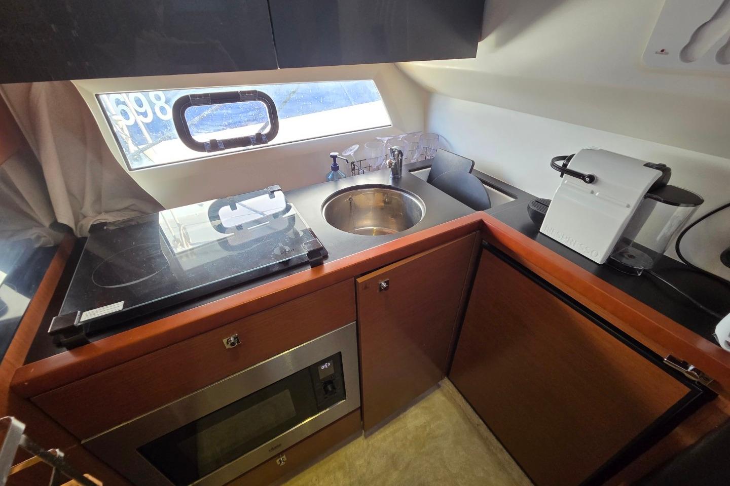 Compact kitchen in 2011 Jeanneau PRESTIGE 350 Flybridge yacht with modern appliances.