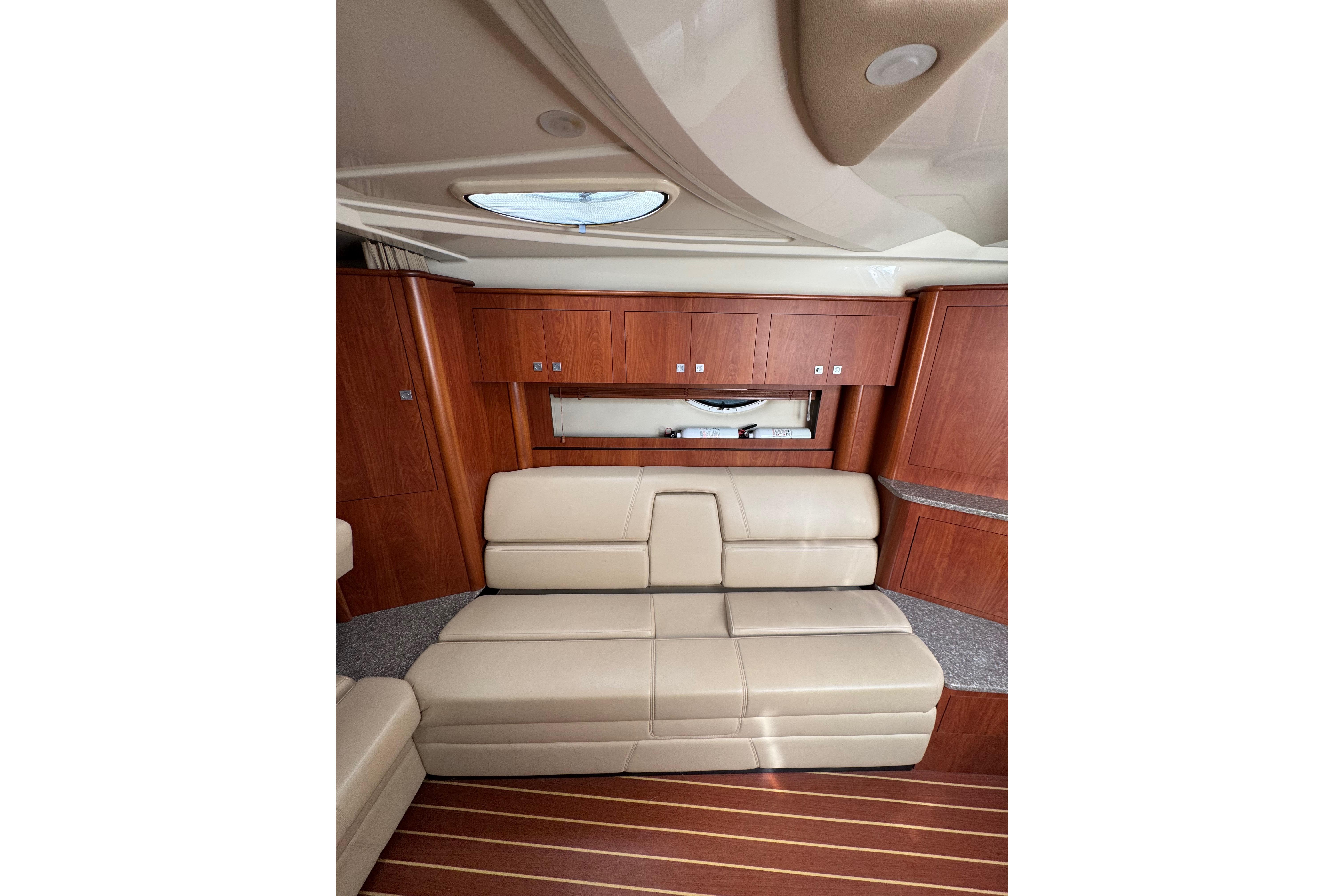 Luxurious interior of 2009 Monterey 320 Sport Yacht with beige leather seating and wooden cabinetry.