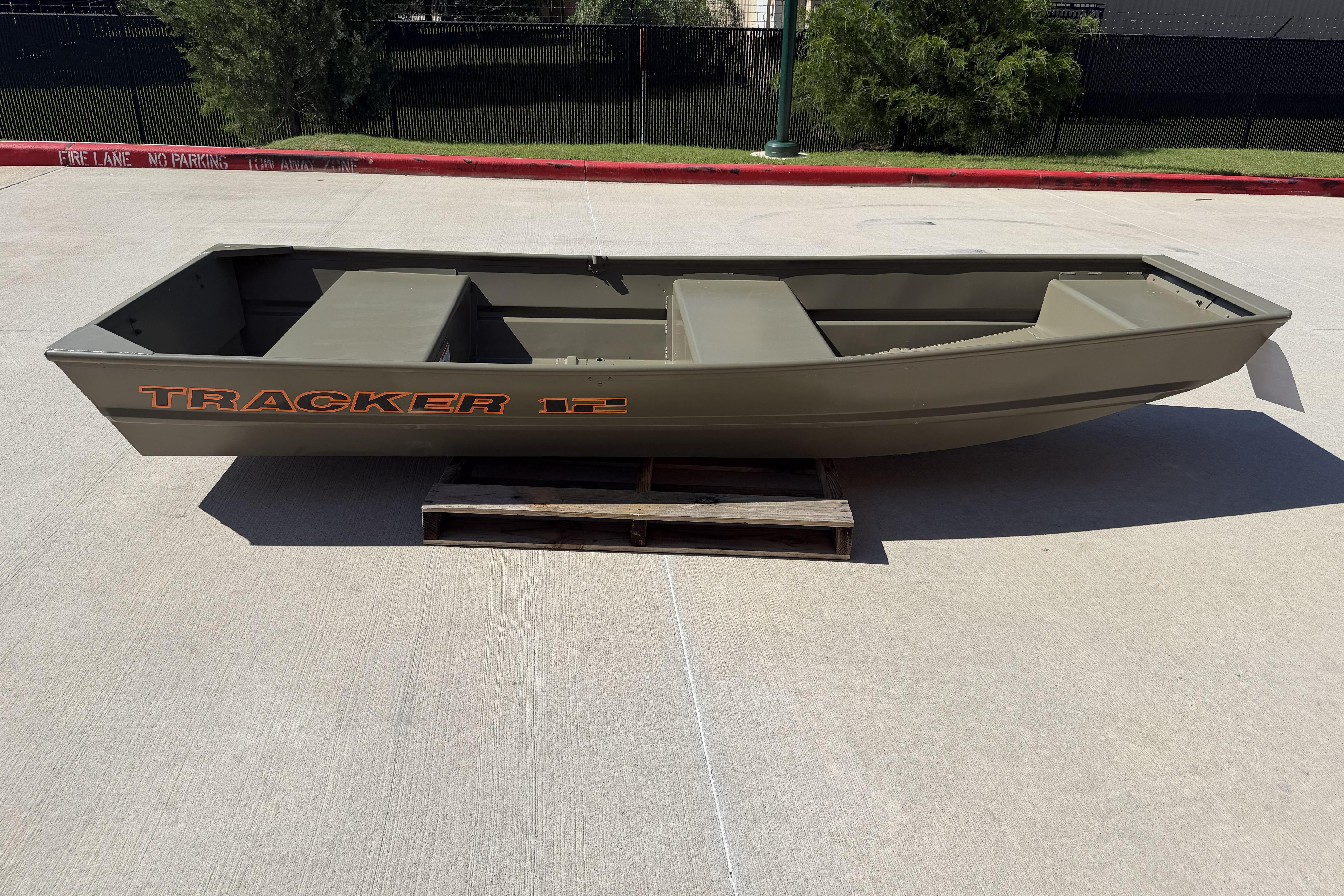 2026 Tracker Grizzly 12 Jon boat displayed outdoors on a wooden pallet.