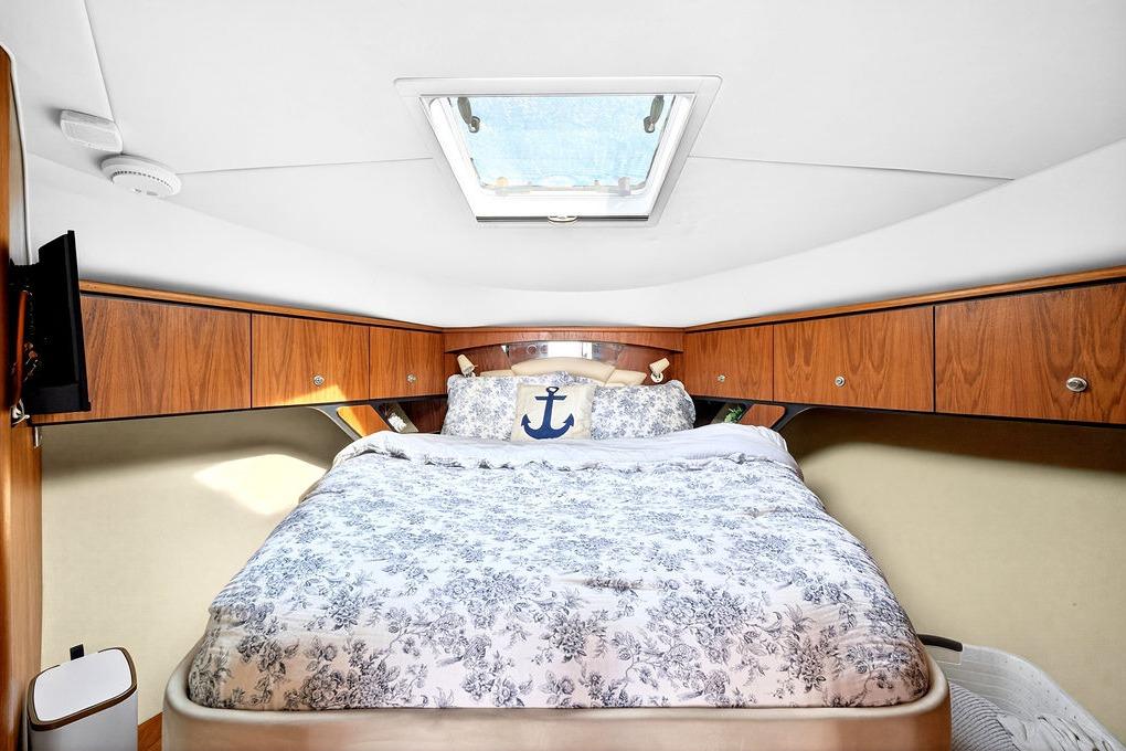 Luxurious cabin interior of 2006 Tiara Yachts 4300 Sovran with skylight and floral bedding.