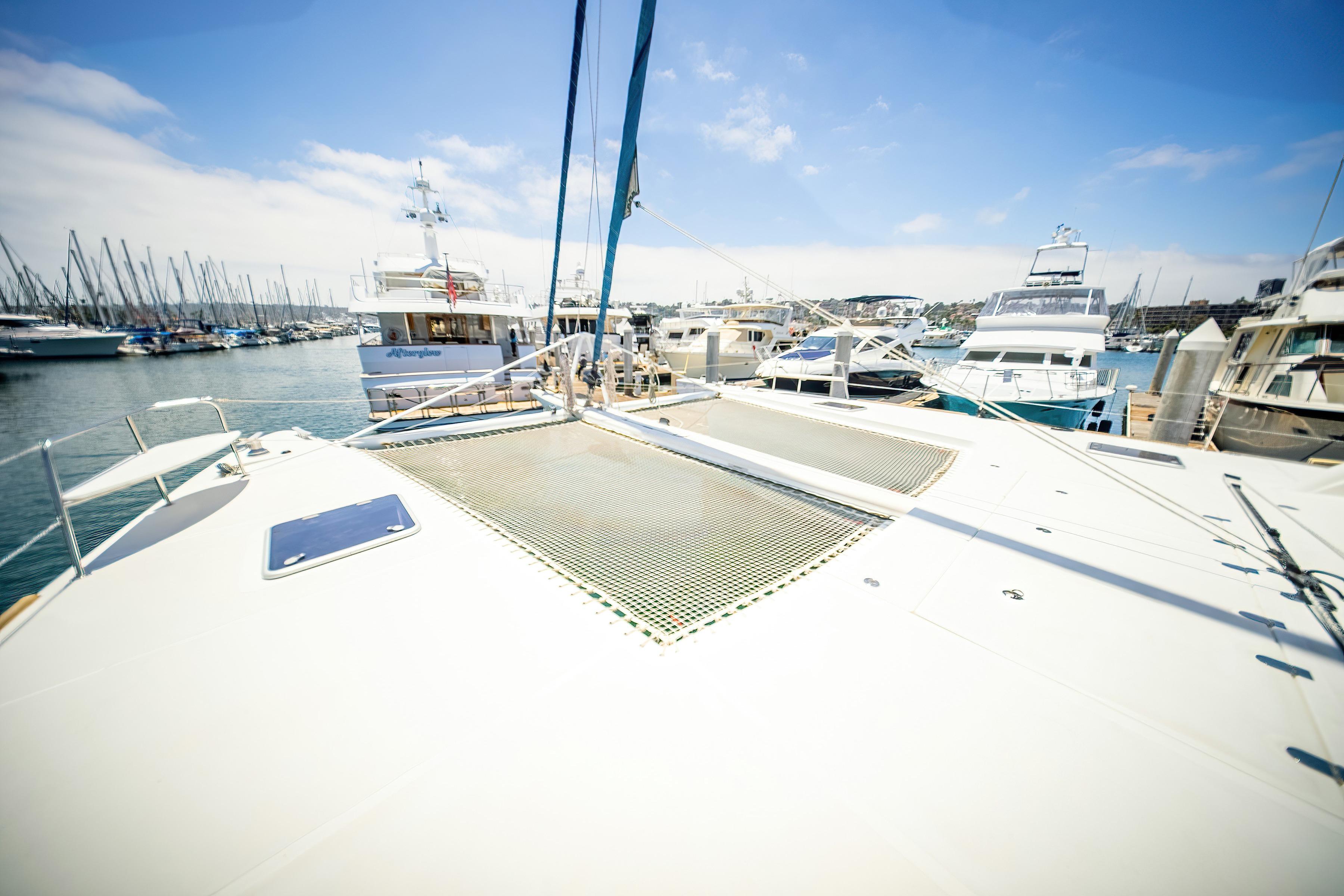 Catana 65 catamaran from 2009 docked in a marina, surrounded by other boats.