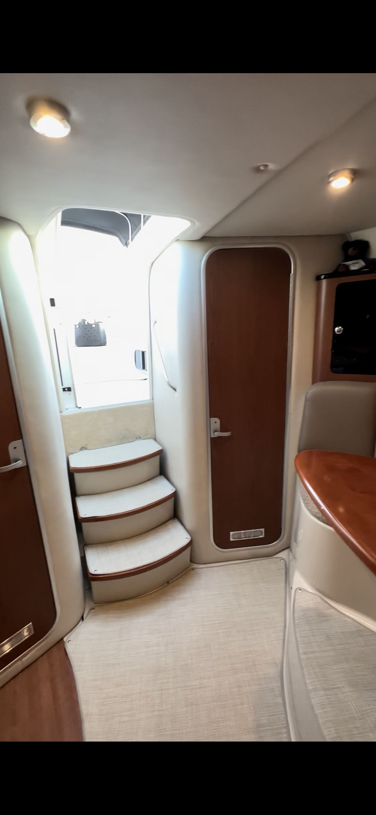 The interior of a 2004 Chaparral Signature 330 features a staircase and wooden doors.