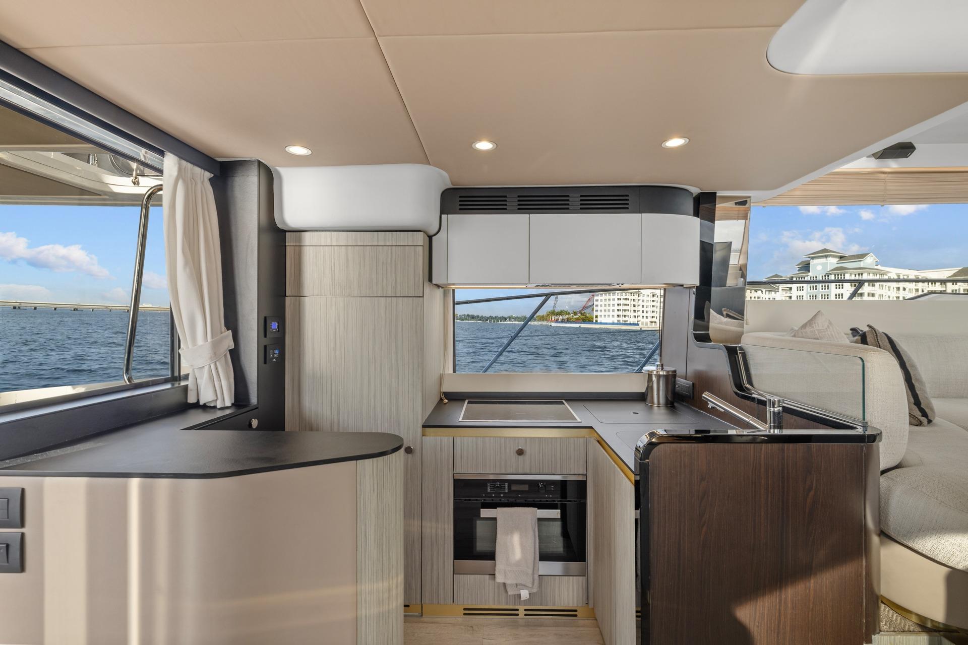 Luxurious interior of 2019 Azimut 55 yacht with modern kitchen and scenic ocean view.