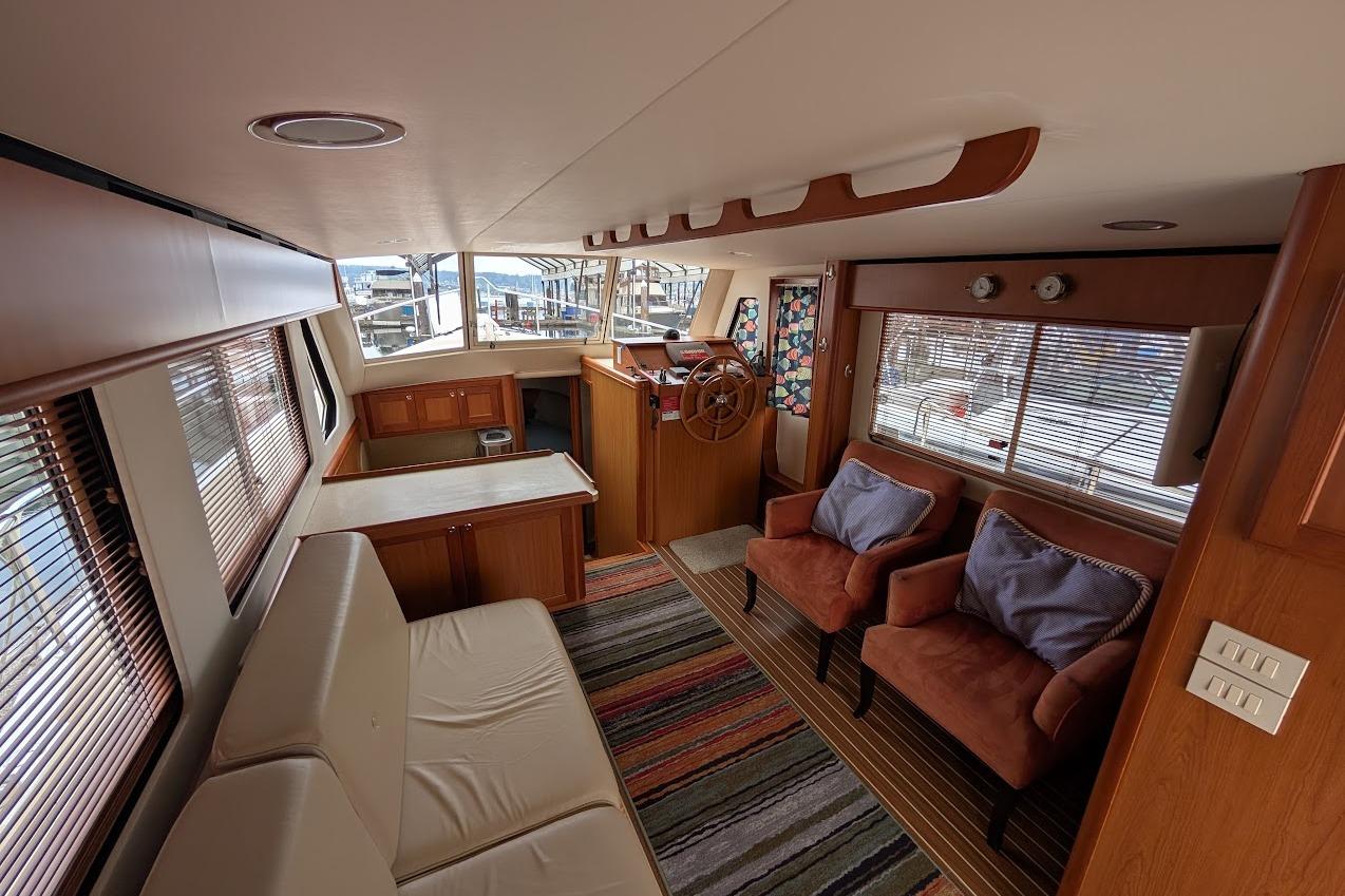 Luxurious interior of 2008 Mainship 38 yacht with cozy seating and helm station.
