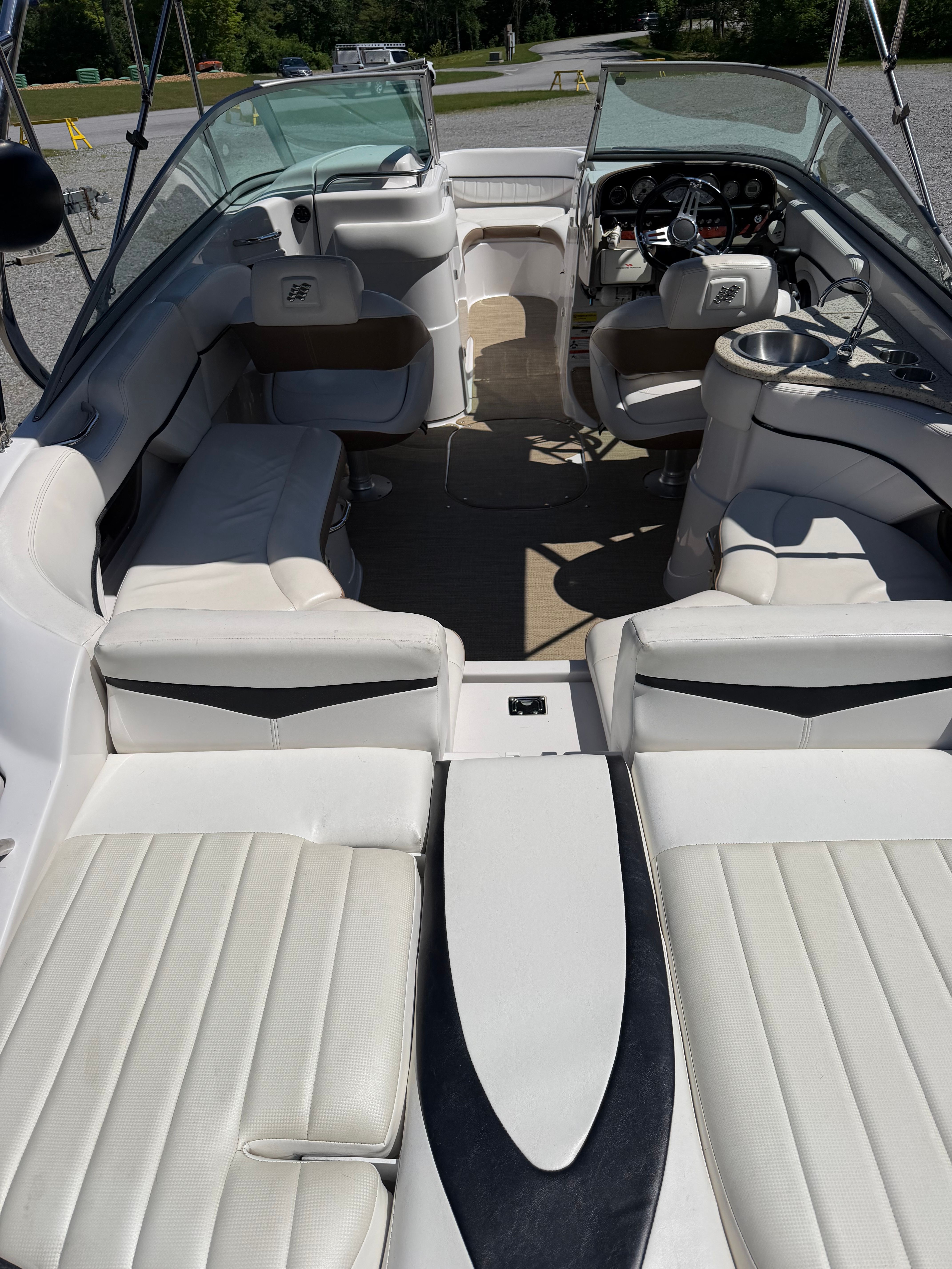 Interior view of a 2008 Four Winns H240 Frenzy with white leather seating and open cockpit.