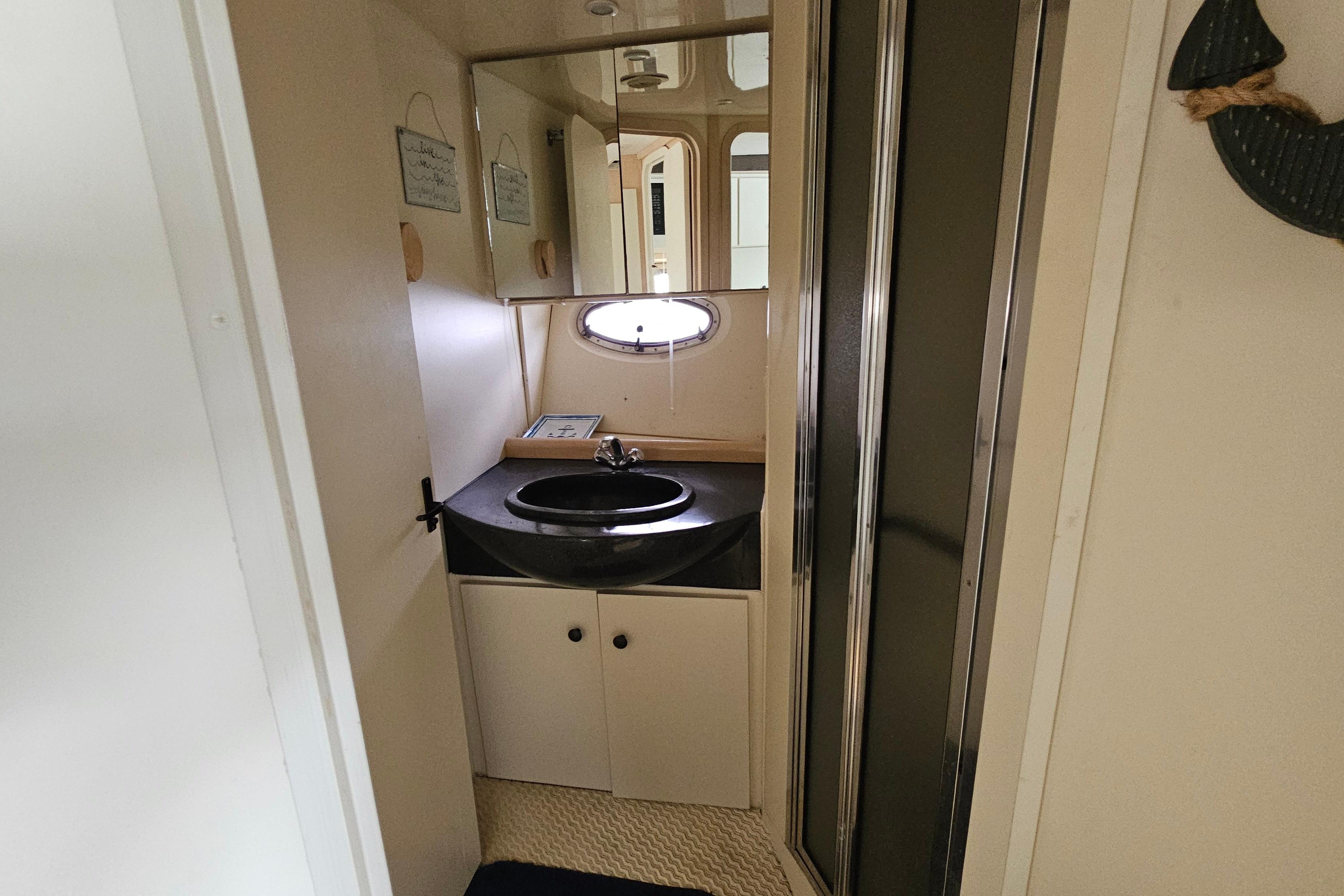 Bathroom interior of a 1999 Carver 350 Mariner yacht, featuring a sink and mirror.