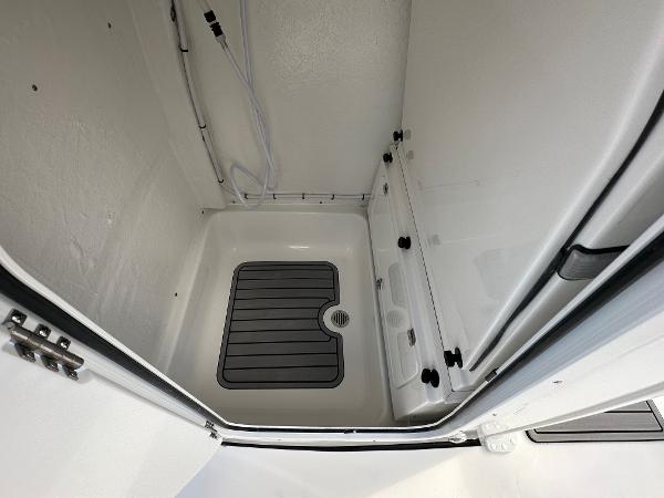 2024 Tidewater 232 SS boat interior storage compartment with drain.