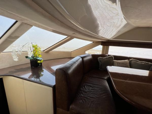 Luxurious interior of 2009 Ovation 52 yacht with leather seating and decorative pillows.