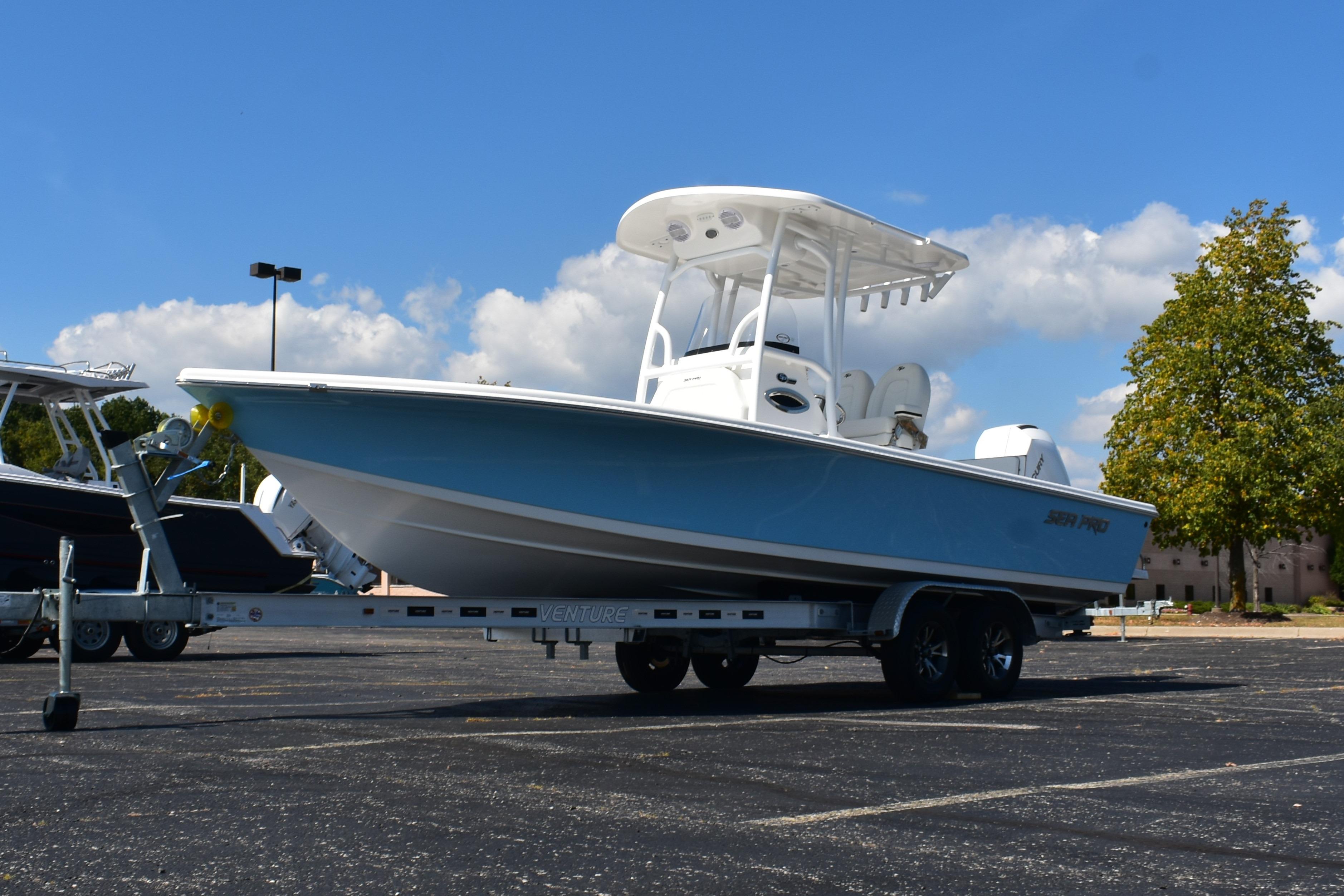 2025 Sea Pro 250 Bay boat on trailer, parked outdoors under blue sky.