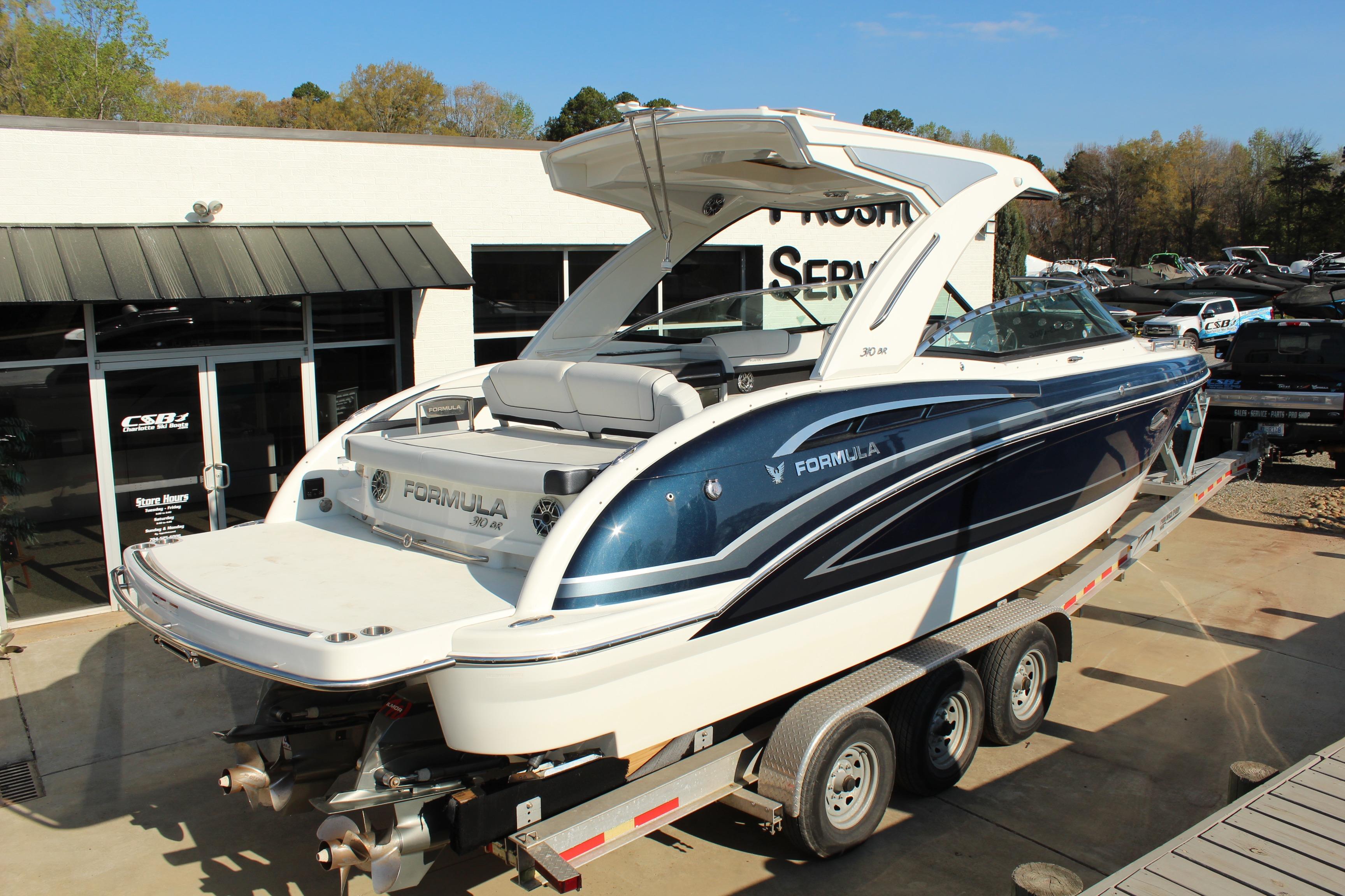 2023 Formula 310 Bowrider I/O boat on trailer, displayed outdoors at dealership.