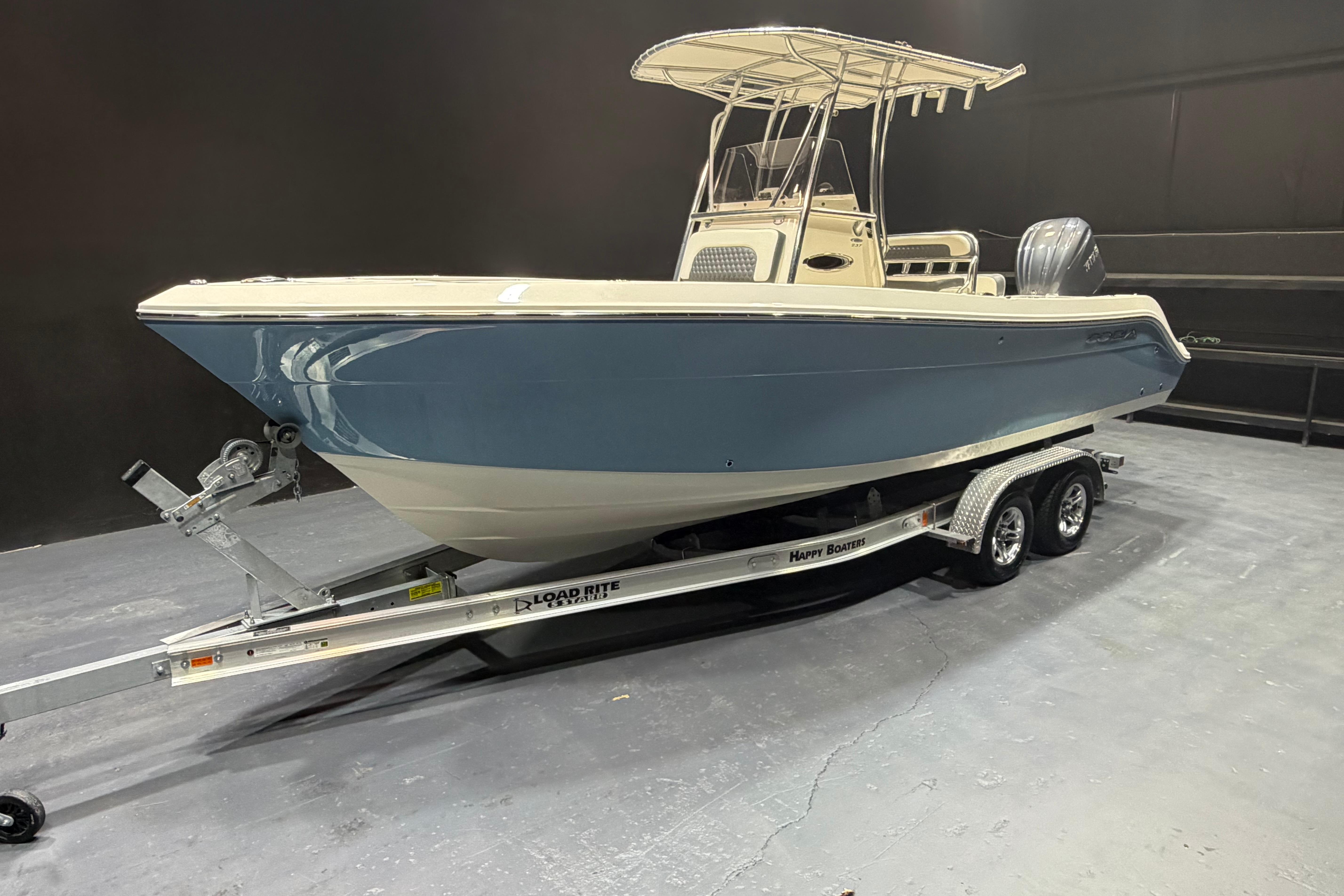 2023 Cobia 237 Center Console boat on trailer, showcased indoors.