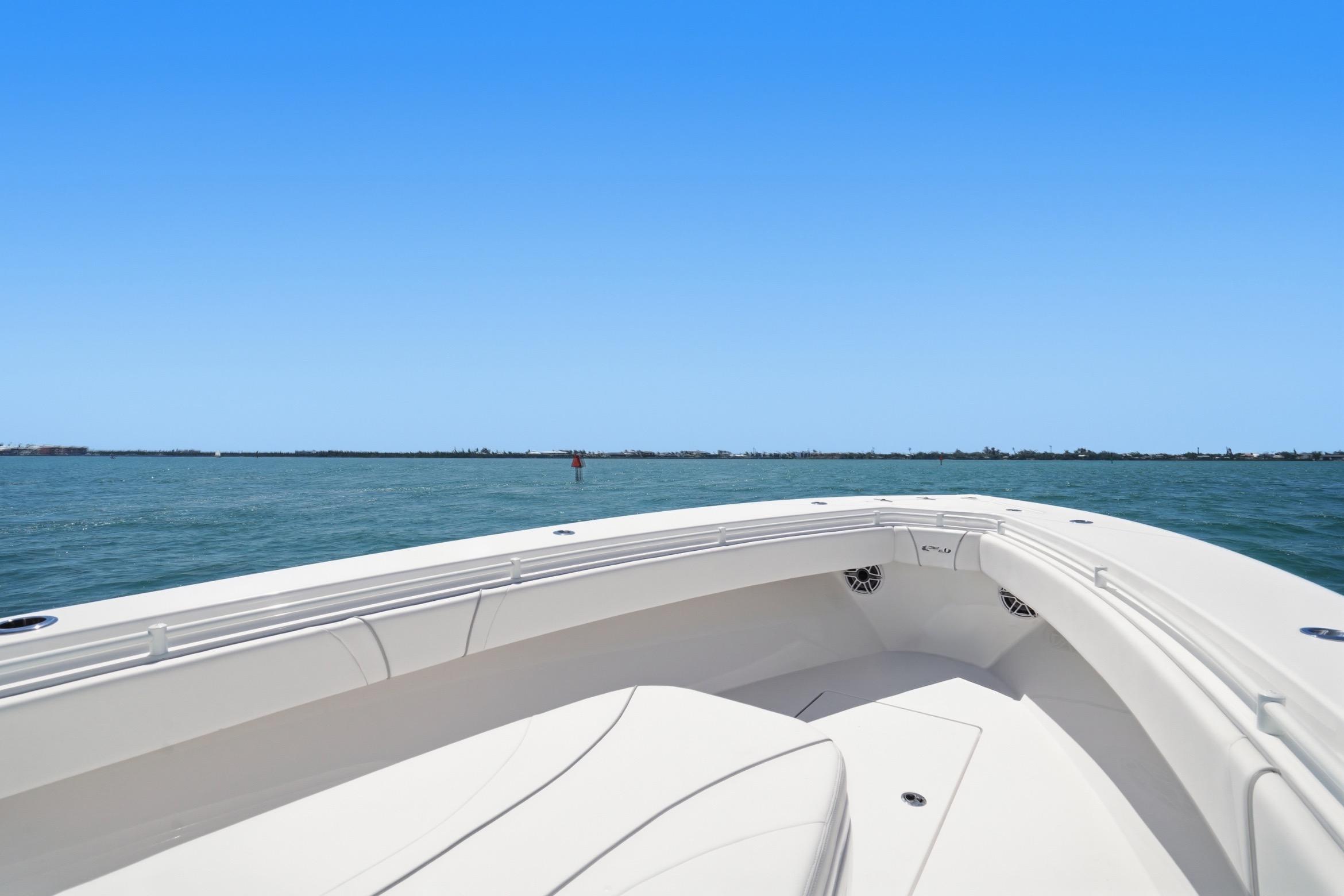 2024 Contender 32 ST boat on open water under clear blue sky.