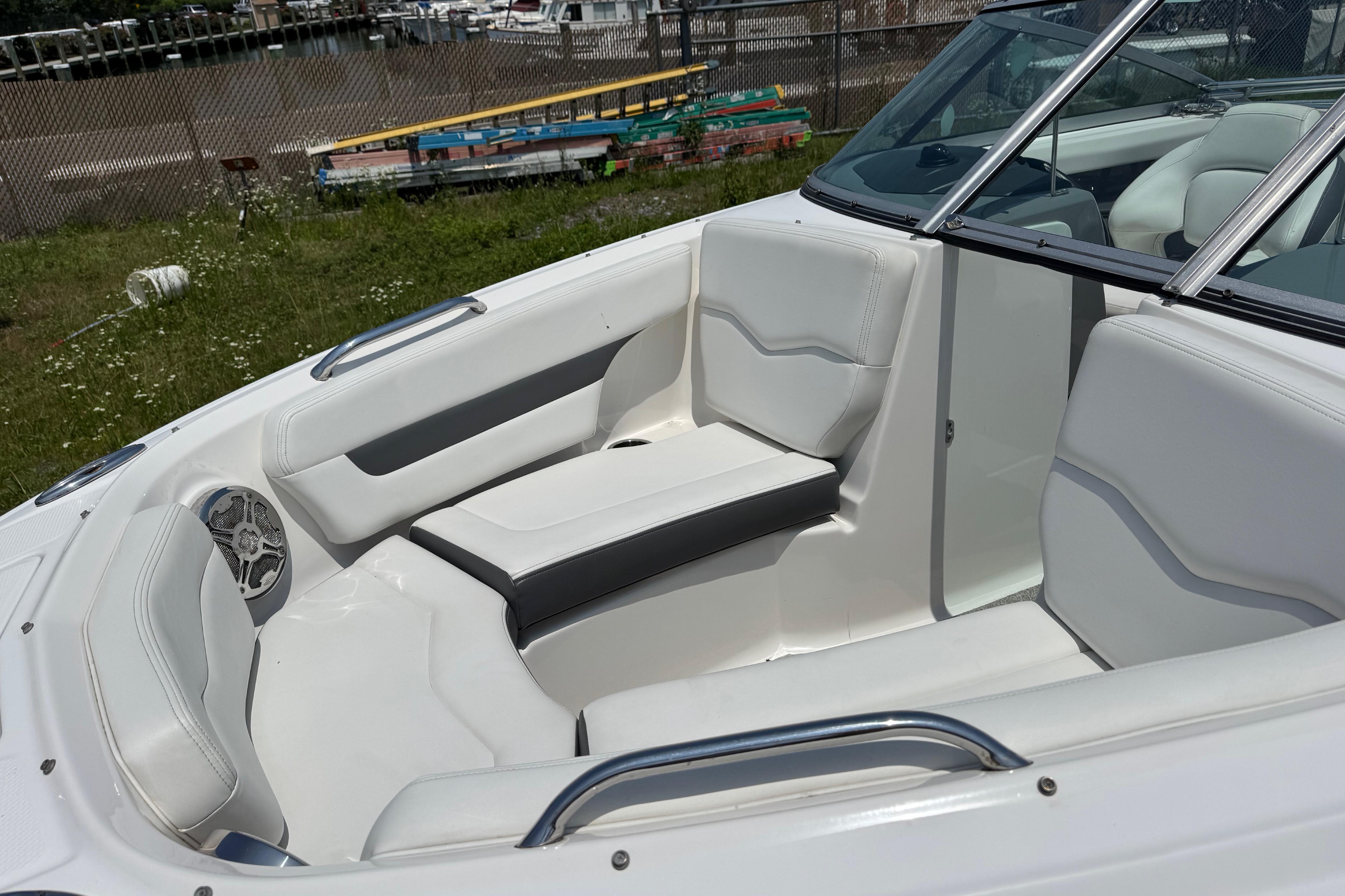 Interior of a 2013 Chaparral 196 SSi boat with white seating and speaker.